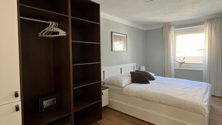 Bedroom, © Jochen Maurer Modern bedroom with double bed, closet and window with curtains.