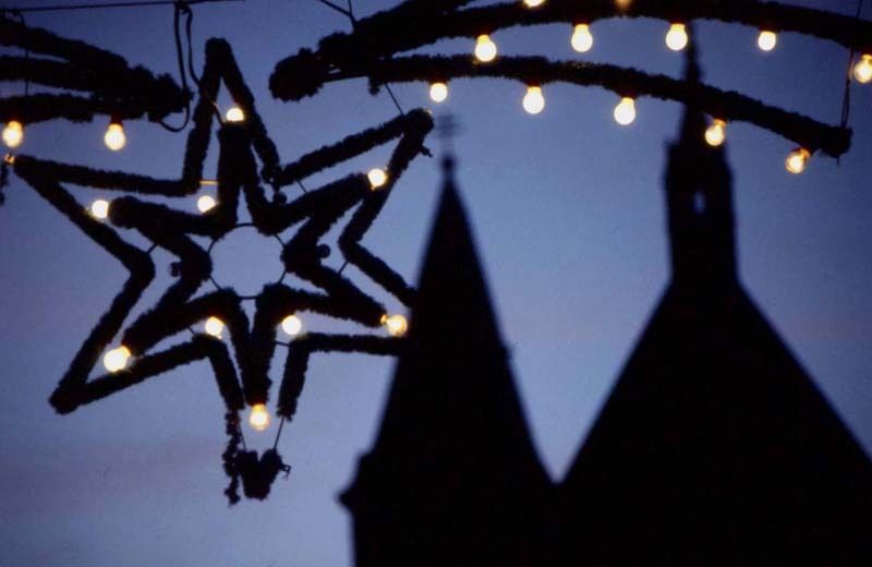 Die Pfarrkirche Eggenburg in der Dunkelheit, davor Weihnachtsbeleuchtung
