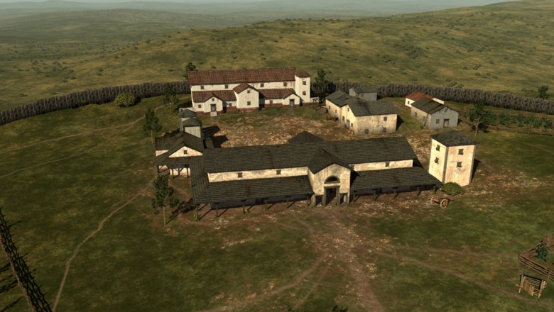 Reconstruction of an ancient settlement on a hill with several buildings and a wooden fence.