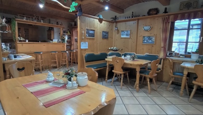 Gemütlicher Frühstücksraum mit Holzmöbeln und Dekorationen.