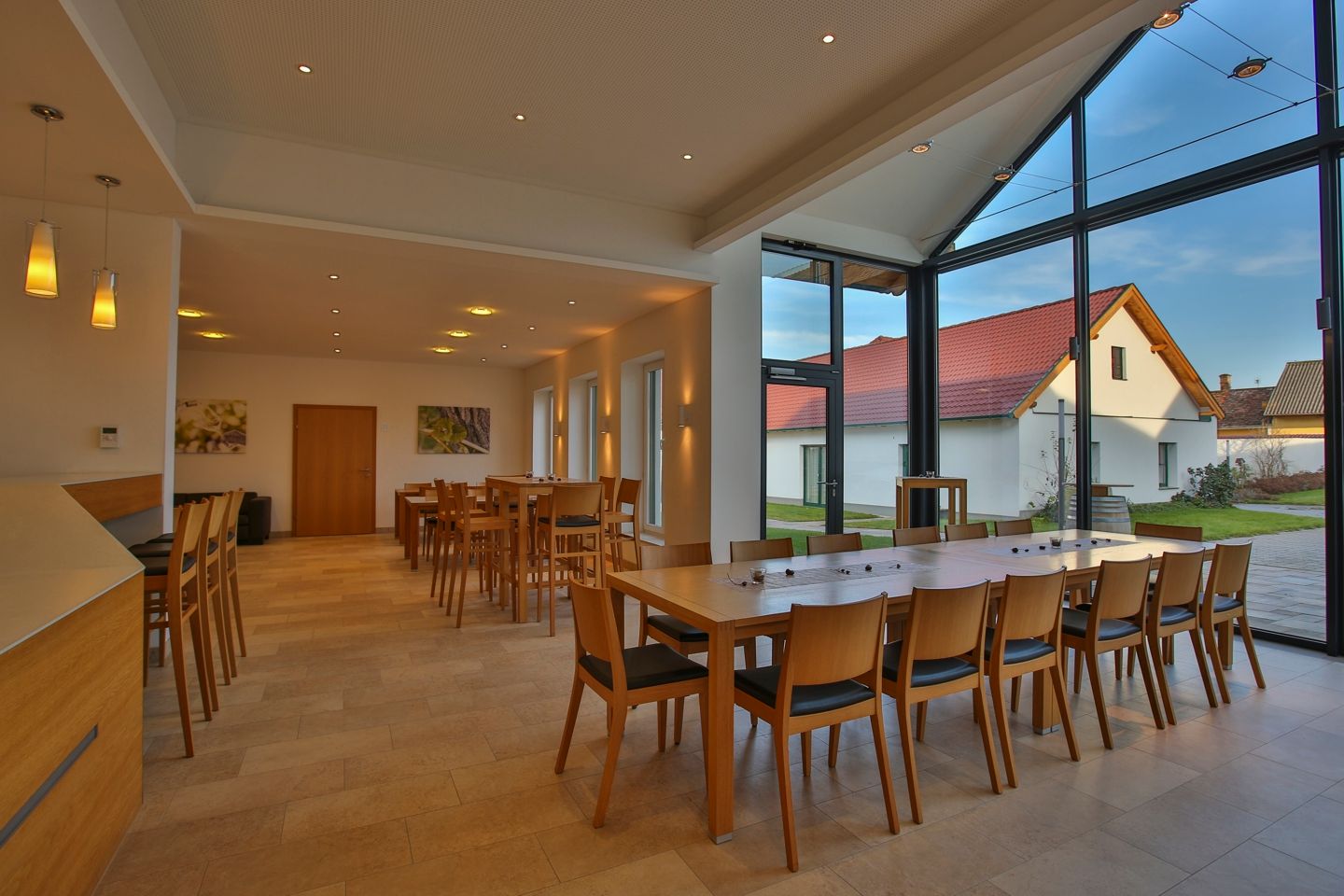 Interior view of a modern tasting room with wooden furniture and large windows.