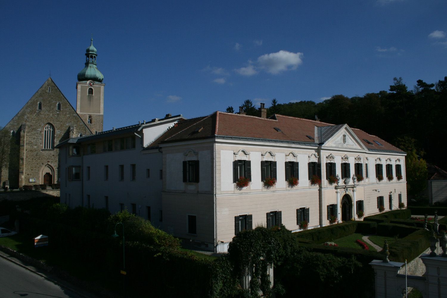 Bildungshaus Schloss Großrußbach mit Kirche im Hintergrund.