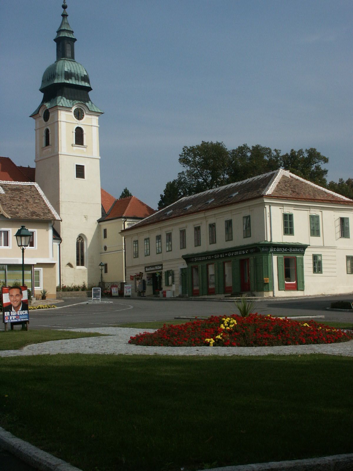 Main square in Sitzendorf with church and flower bed.