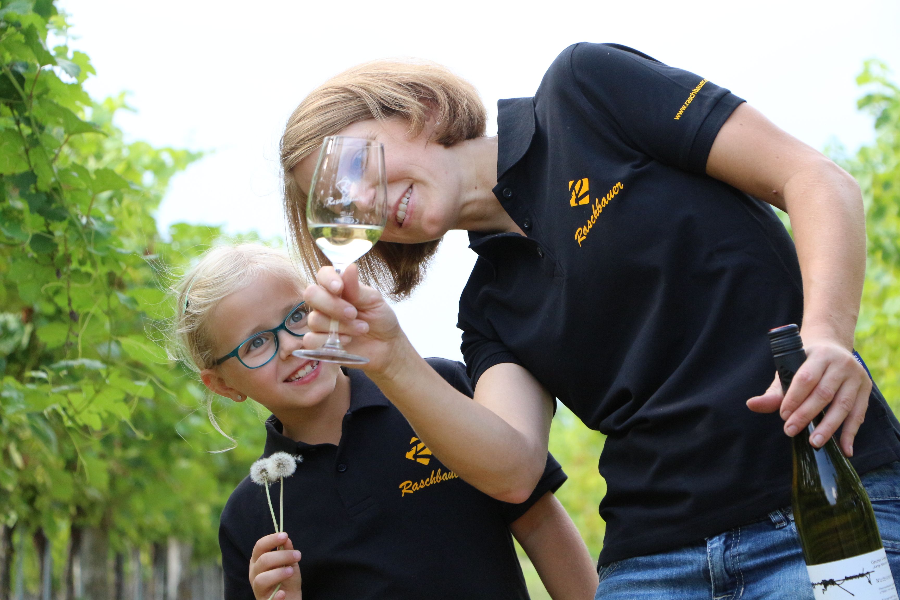 Woman and child in the vineyard with wine glass and dandelion.