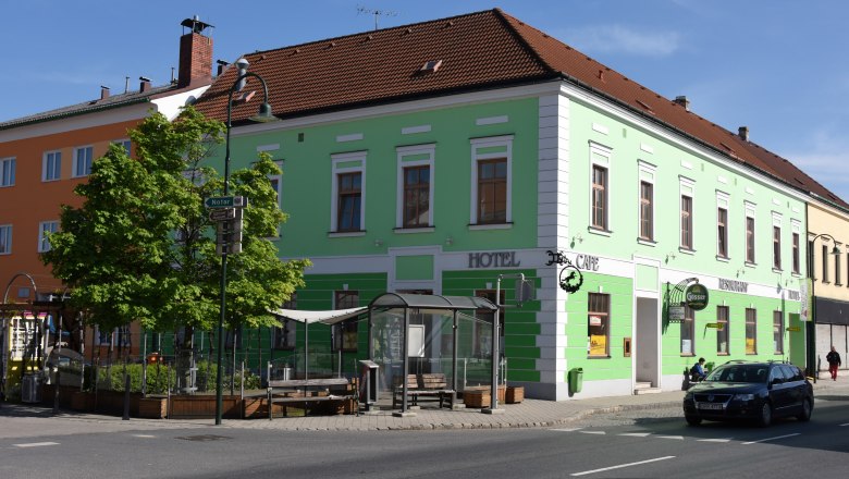Weinhotel Rieder, © Familie Rieder Grünes Gebäude mit Hotel- und Café-Schildern an einer Straßenecke.