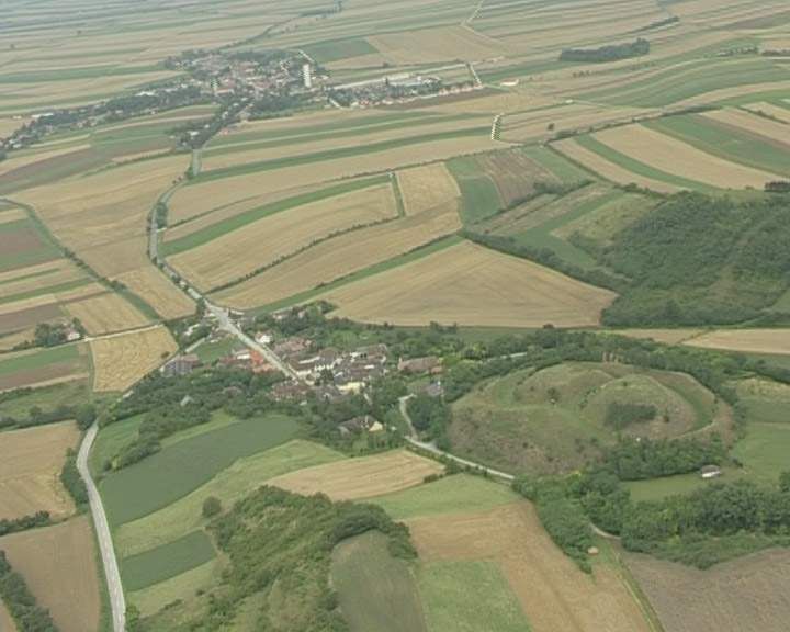 Letecký pohľad na vidiecku krajinu s poliami a malou dedinou.