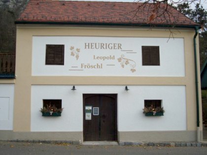 Fassade eines Heurigenlokals mit der Aufschrift 'Heuriger Leopold Fröschl'.