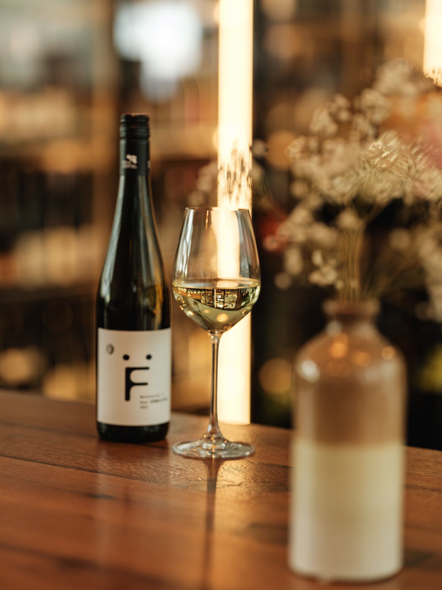 Ein eleganter Weißwein in einem stilvollen Glas reflektiert das Licht der Vinothek und lädt zu genussvollen Momenten ein. Die sanften Aromen des Weins harmonieren perfekt mit der gemütlichen Atmosphäre, die hier im Weinviertel herrscht. Ein idealer Ort, um die kulinarischen Köstlichkeiten der Region zu entdecken.