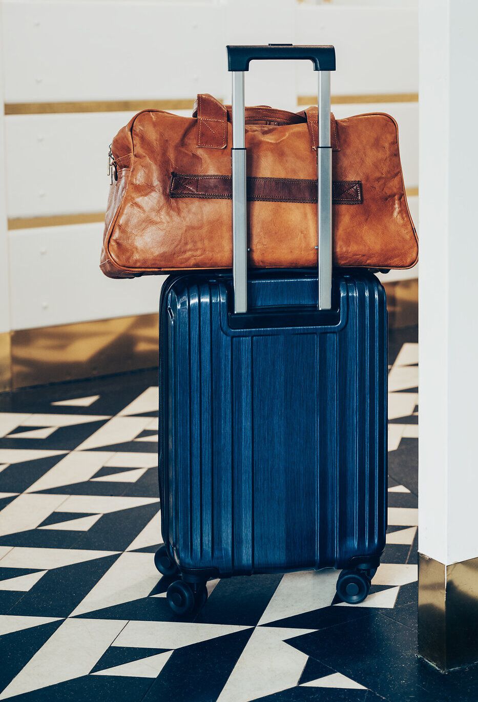 Ein eleganter Koffer und eine stilvolle Reisetasche stehen bereit, um die Abenteuer in den Wiener Alpen zu beginnen. Die helle, einladende Rezeption strahlt eine warme Atmosphäre aus, die Reisende dazu einlädt, die Schönheit der umliegenden Natur zu erkunden. Hier beginnt die Reise in eine Welt voller atemberaubender Ausblicke und unvergesslicher Erlebnisse.