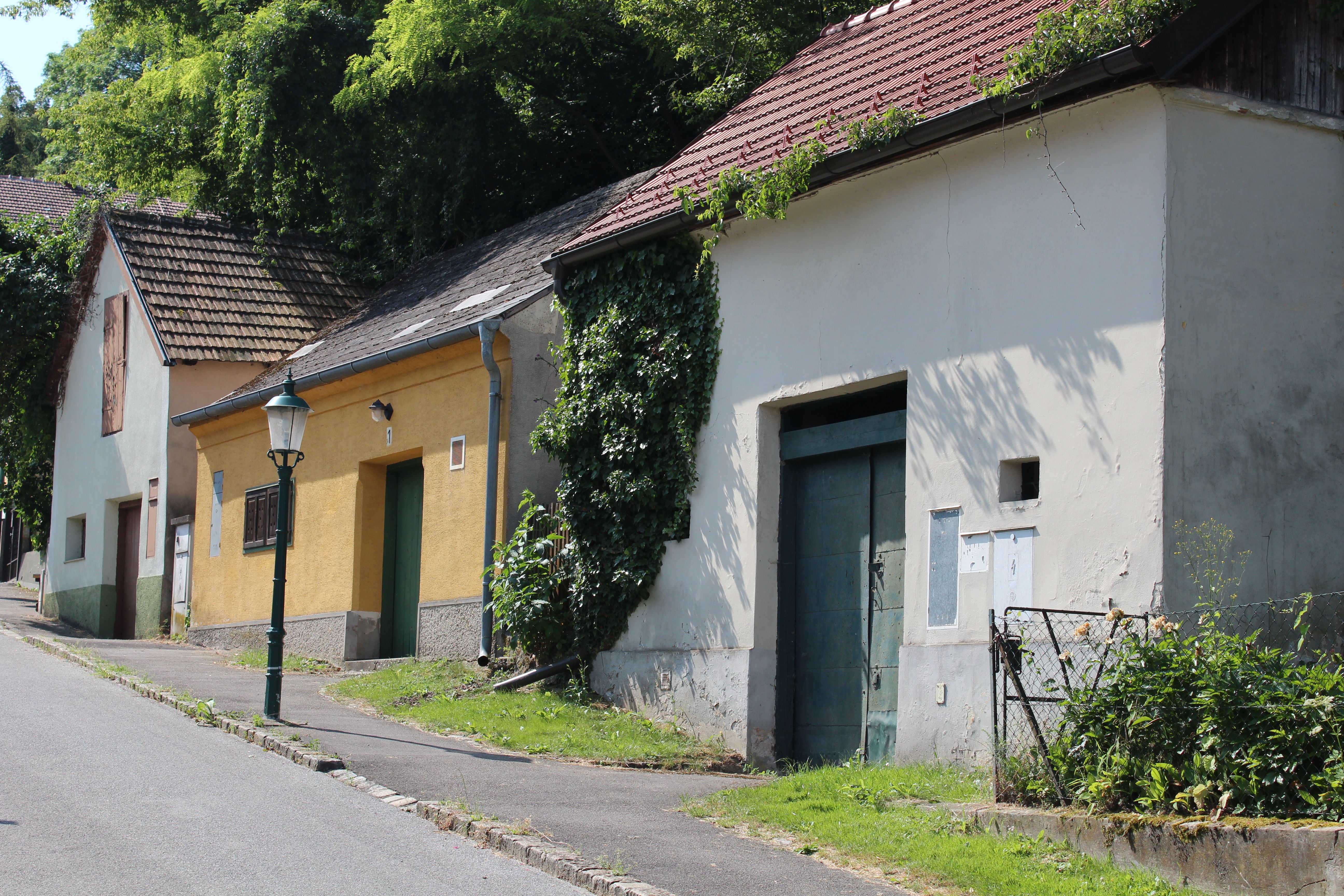 Kellergasse mit alten Gebäuden und Laterne in Bisamberg.