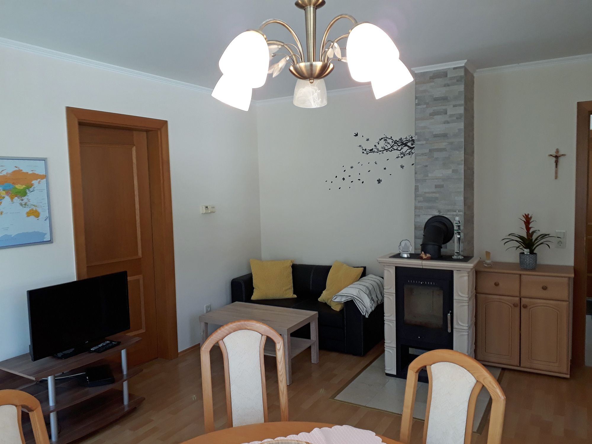 Wohnzimmer mit Kamin, Sofa, Tisch und Fernseher.