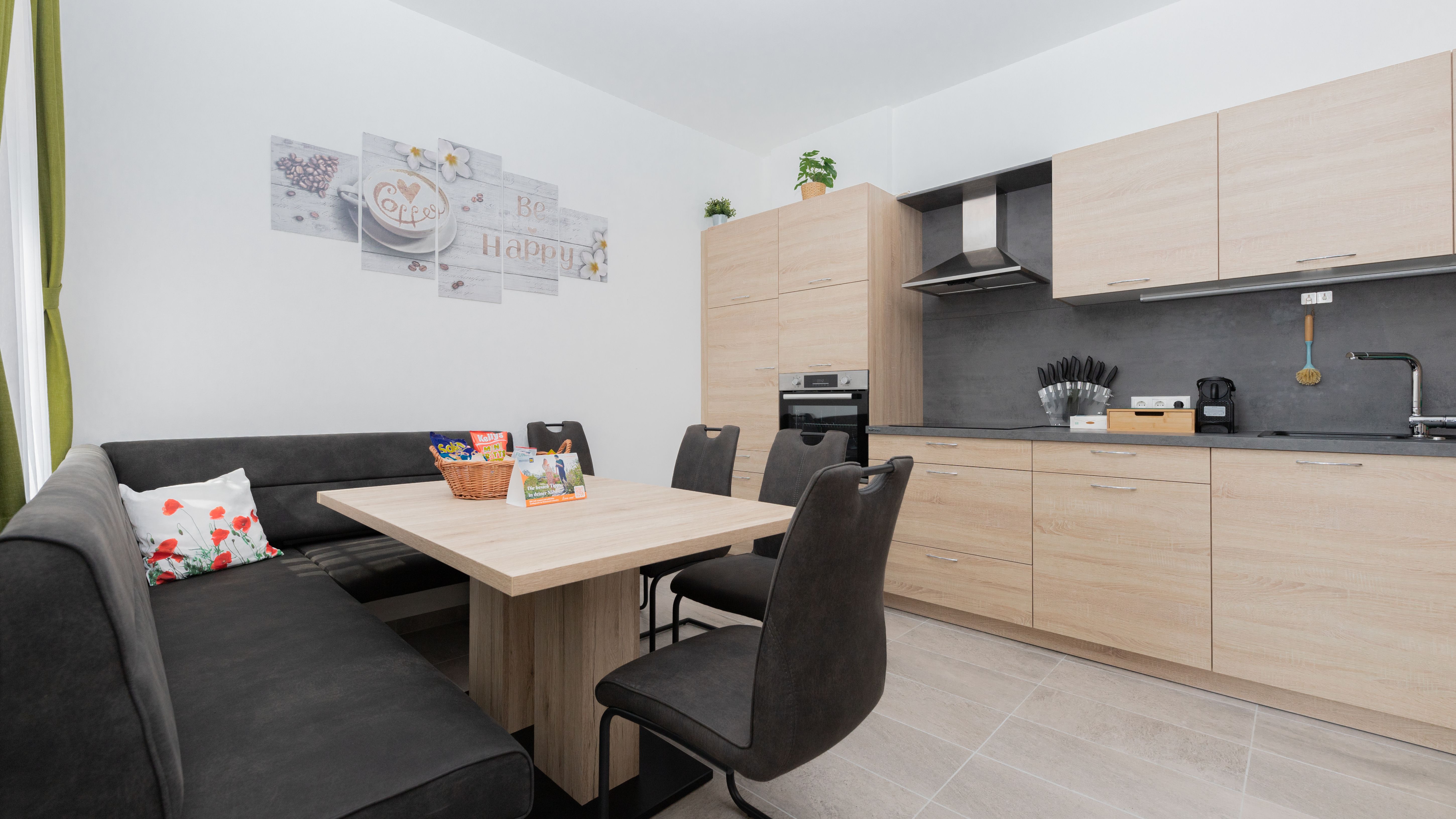 Moderne Küche mit Holzmöbeln, Esstisch, Eckbank und Stühlen.