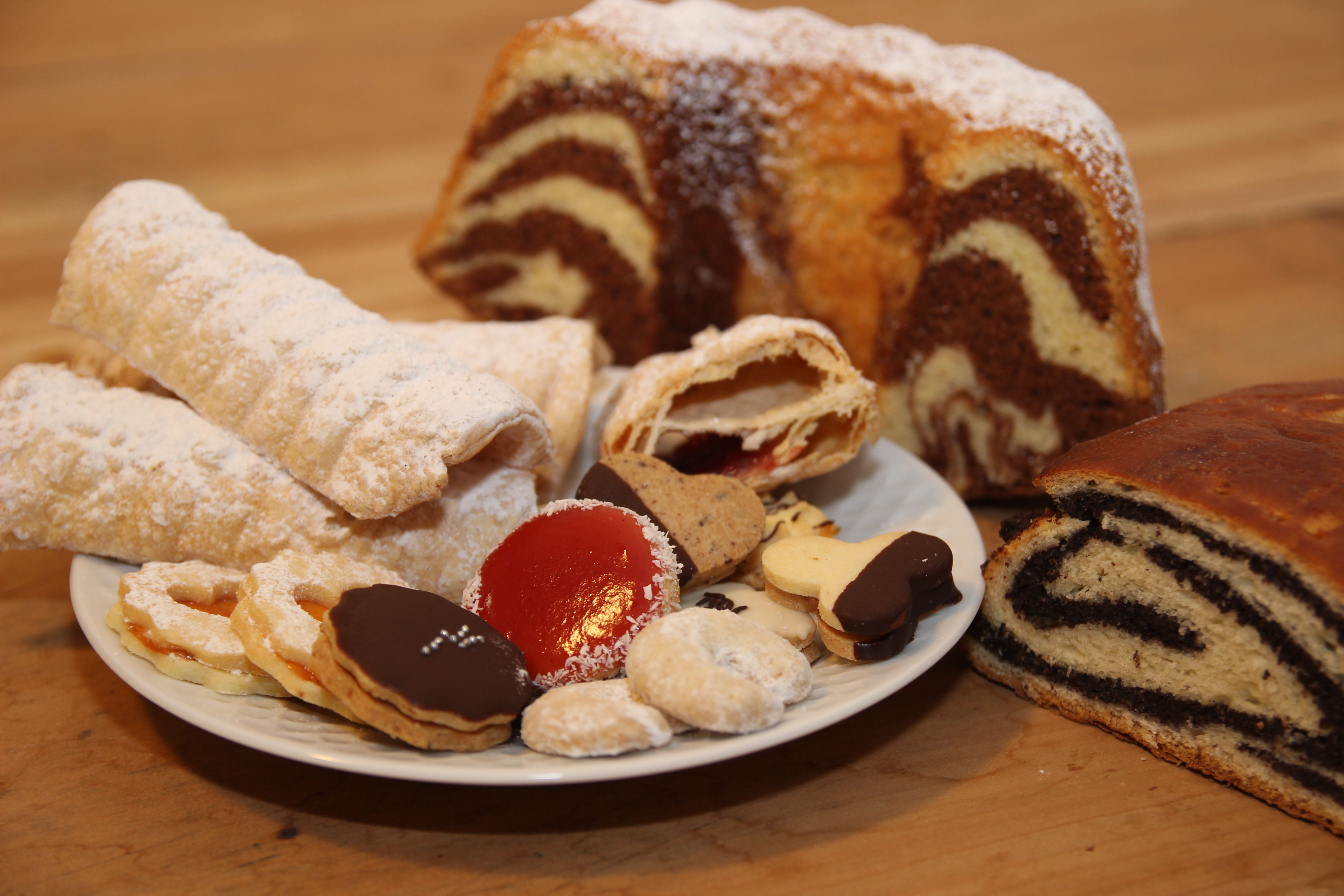 Verschiedene Gebäcksorten auf einem Teller, darunter Kekse, Strudel und Marmorkuchen.