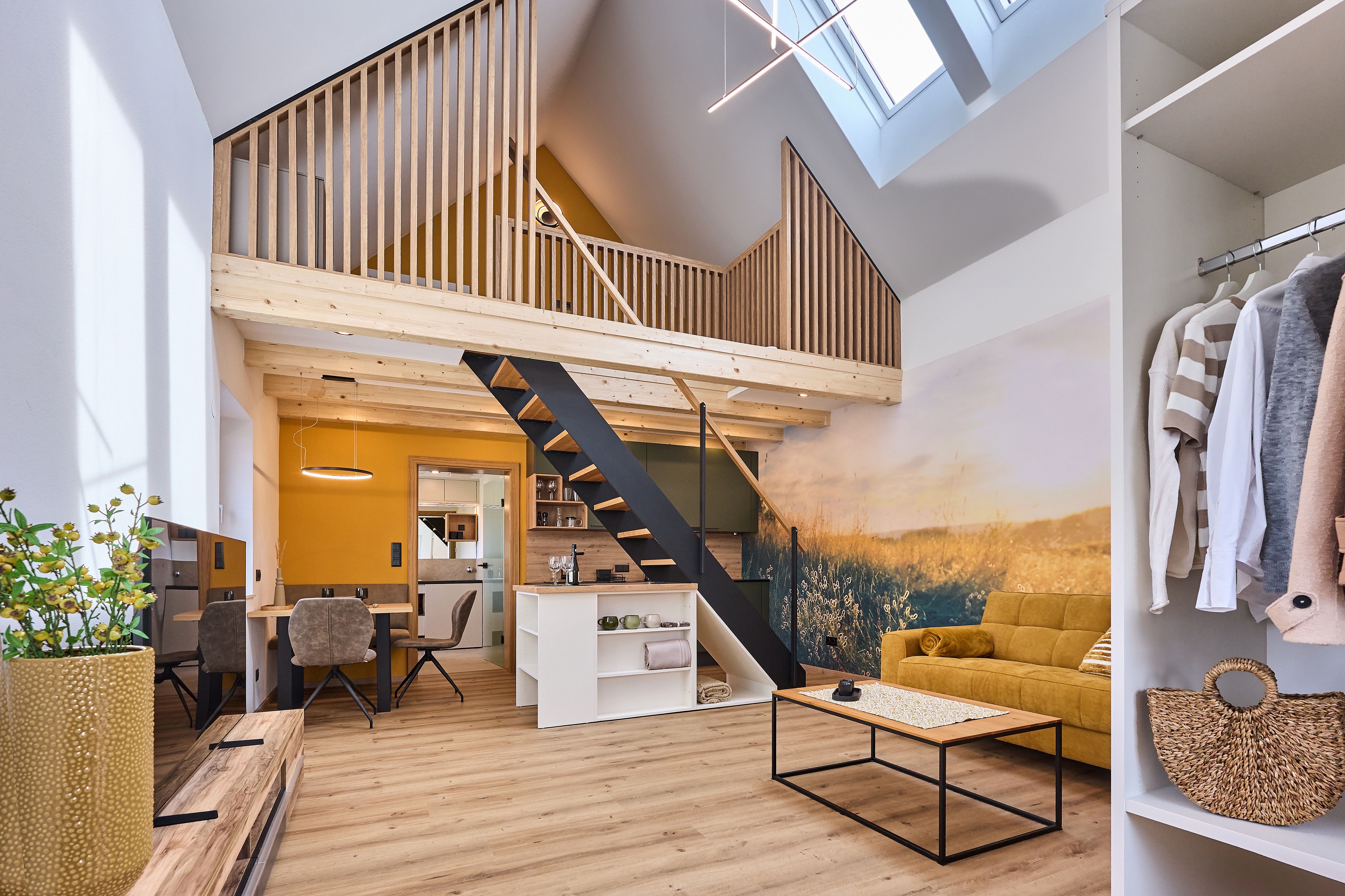 Modernes Loft mit offener Galerie, gelbem Sofa und Holzelementen.