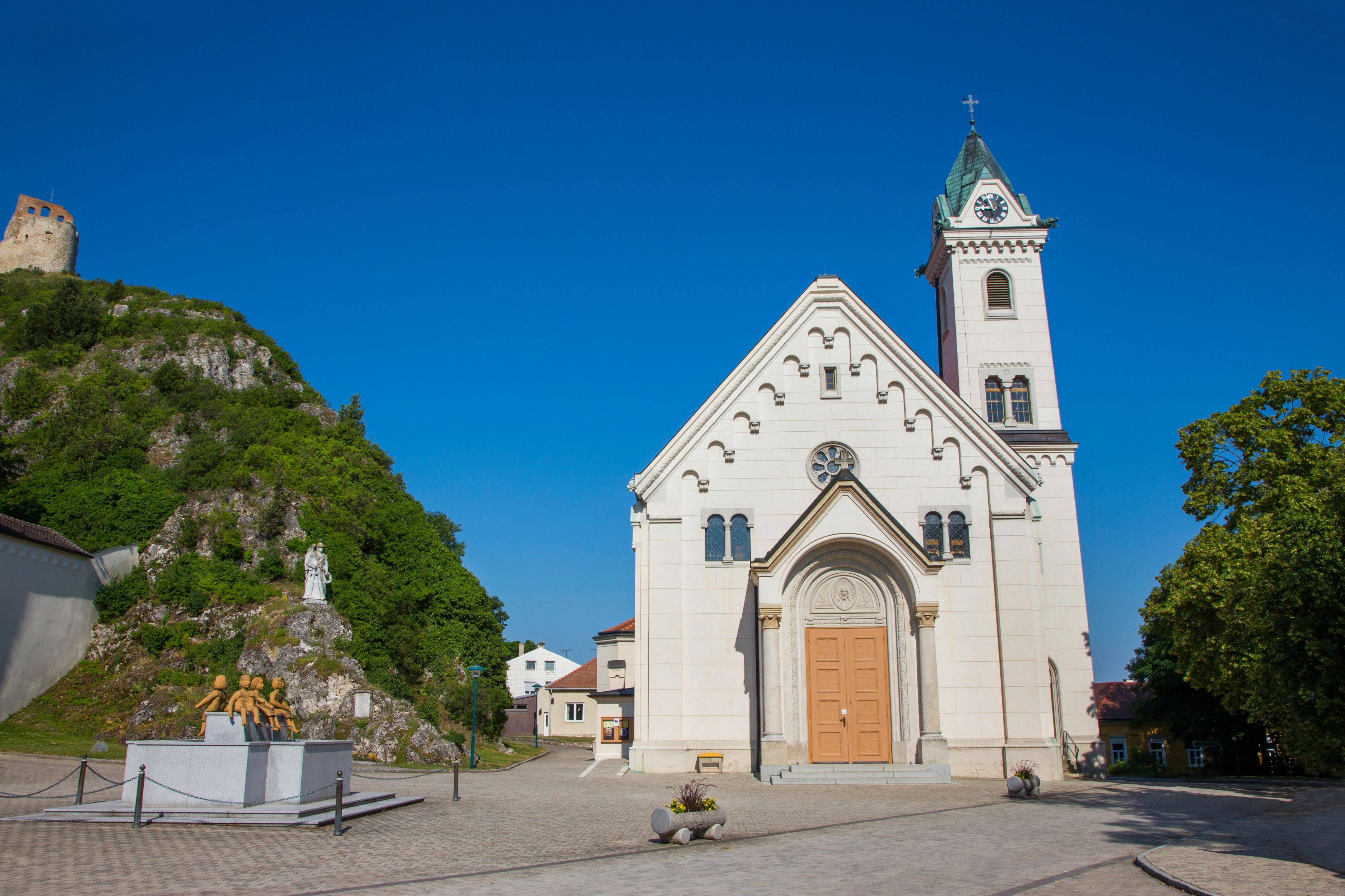 Proboštský kostel ve Staatzu se zříceninou hradu v pozadí.