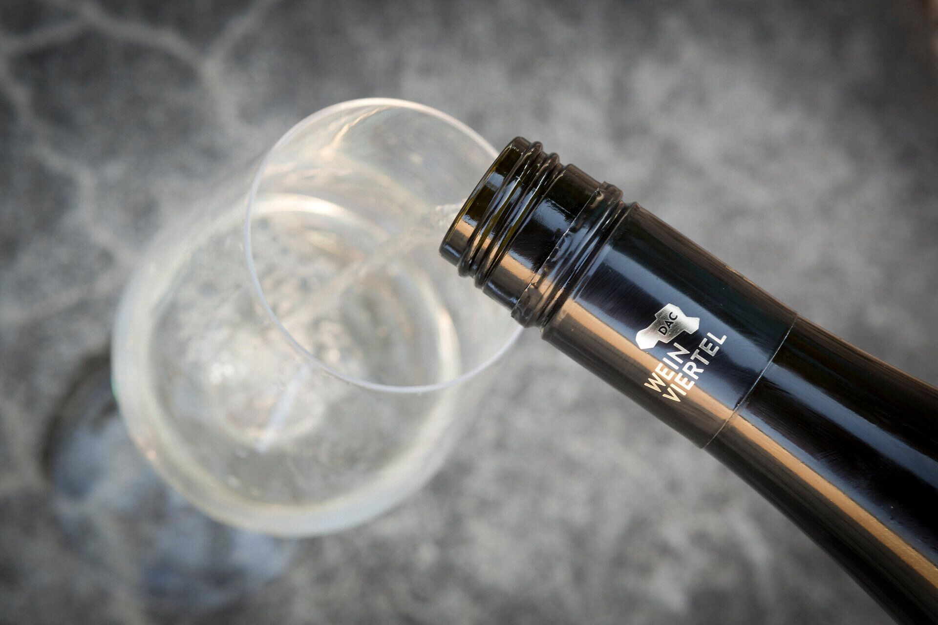 Ein elegantes Weinglas wird behutsam mit sprudelndem Wein gefüllt, während die sanften Lichtreflexe auf der Oberfläche tanzen. Diese Szene verkörpert die Genusskultur der Region, wo exquisite Weine und kulinarische Entdeckungen aufeinander treffen. Lassen Sie sich von der Vielfalt und dem Reichtum der Aromen verführen.