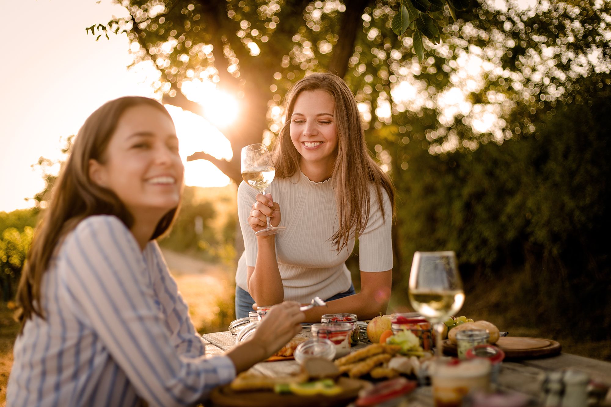 Zwei junge Frauen genießen ein Picknick im Weinviertel.