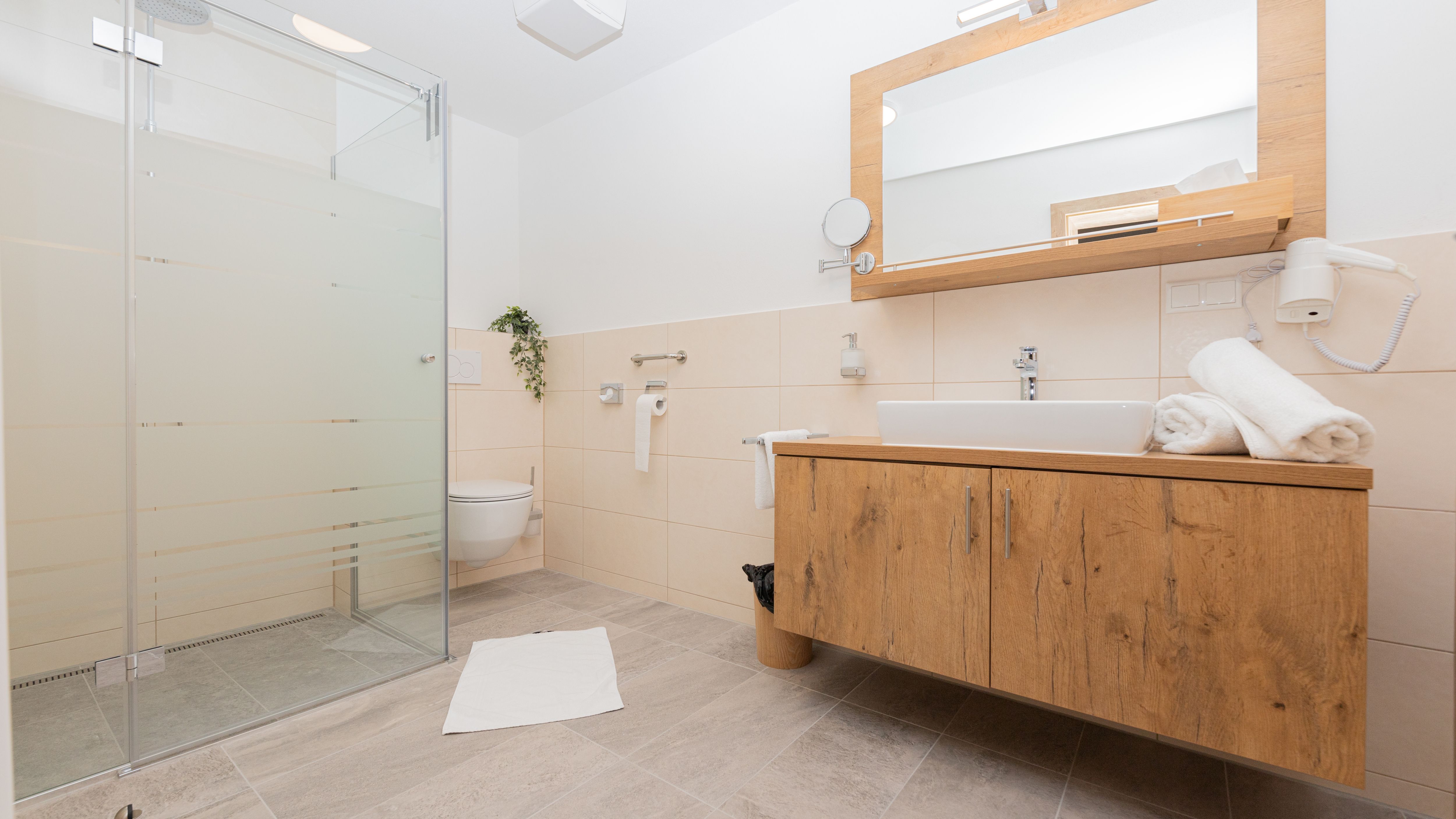Modernes Badezimmer mit Dusche, Waschbecken und Toilette.