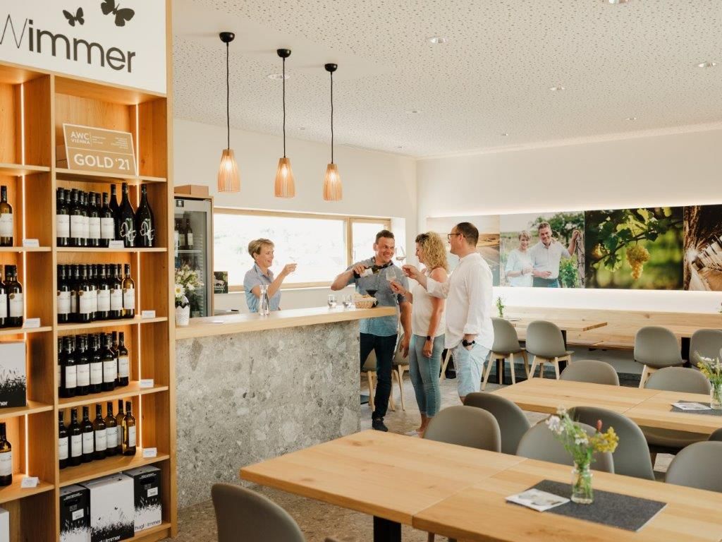 In einem modernen Verkostungsraum eines Weinguts wird Wein eingeschenkt.