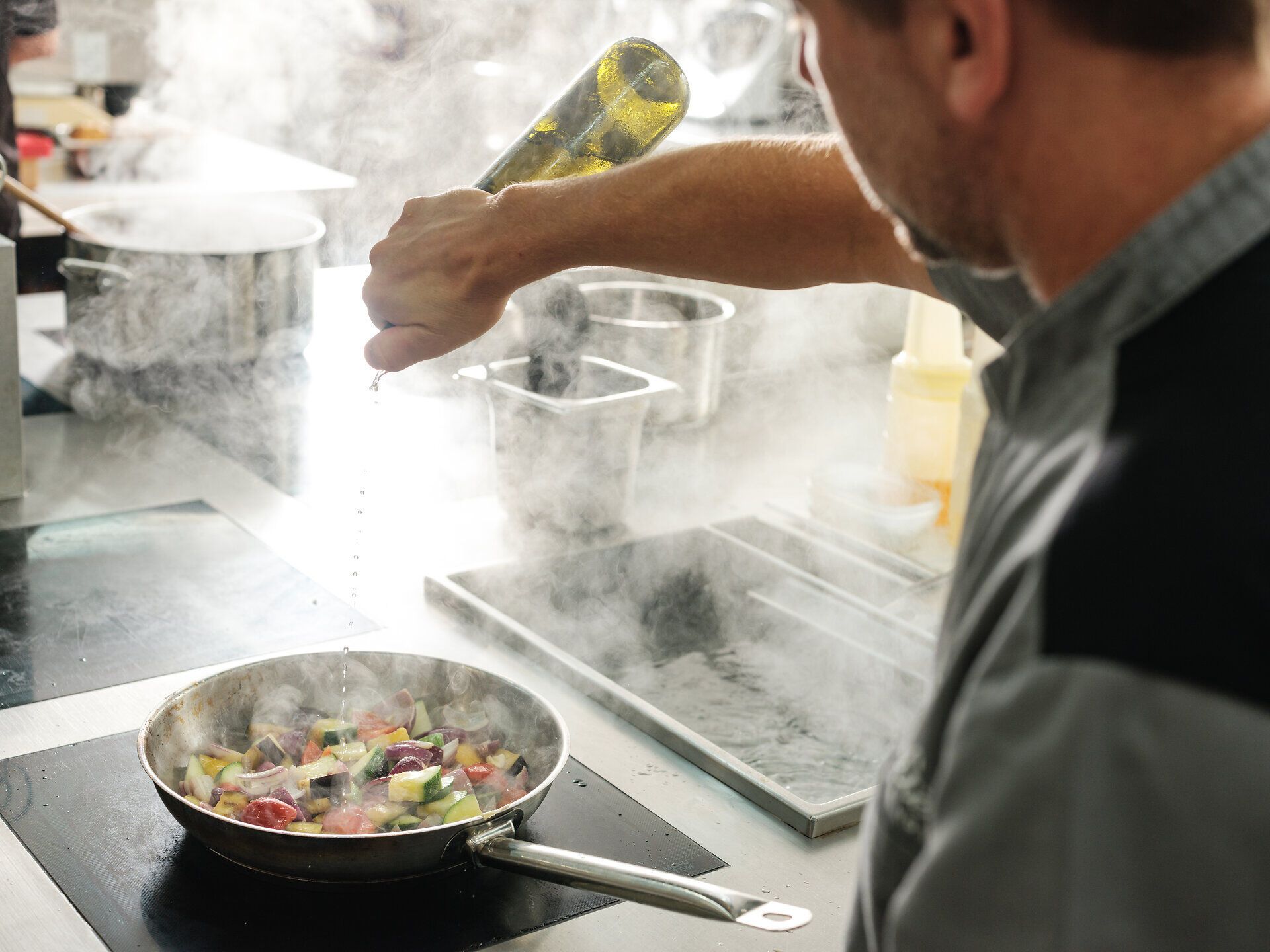 In der dampfenden Küche wird mit Leidenschaft ein köstliches Gericht zubereitet, während frische, bunte Gemüsezutaten in der Pfanne brutzeln. Der Duft von Kräutern und Gewürzen erfüllt den Raum und verspricht ein unvergessliches kulinarisches Erlebnis. Hier wird die Kunst der Gastronomie zelebriert, die die Sinne verführt.