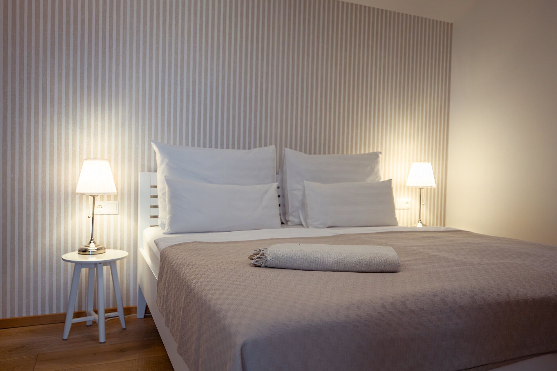 In einem stilvoll eingerichteten Schlafzimmer mit sanften Farben und warmem Licht lädt die gemütliche Atmosphäre zum Entspannen ein. Die harmonische Gestaltung und die ruhige Umgebung schaffen den perfekten Rückzugsort für einen erholsamen Aufenthalt.