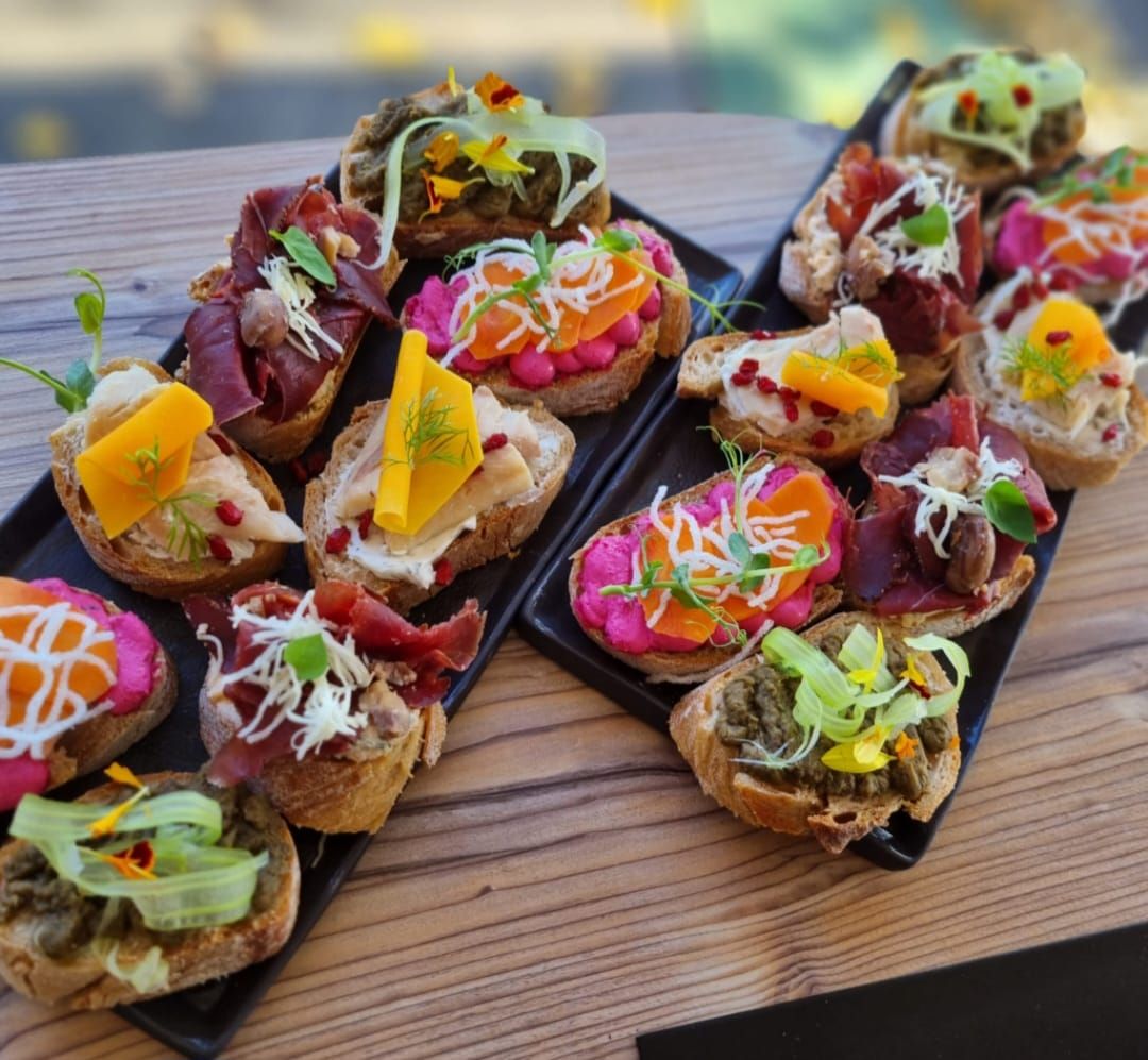 Verschiedene belegte Brötchen auf zwei schwarzen Platten.