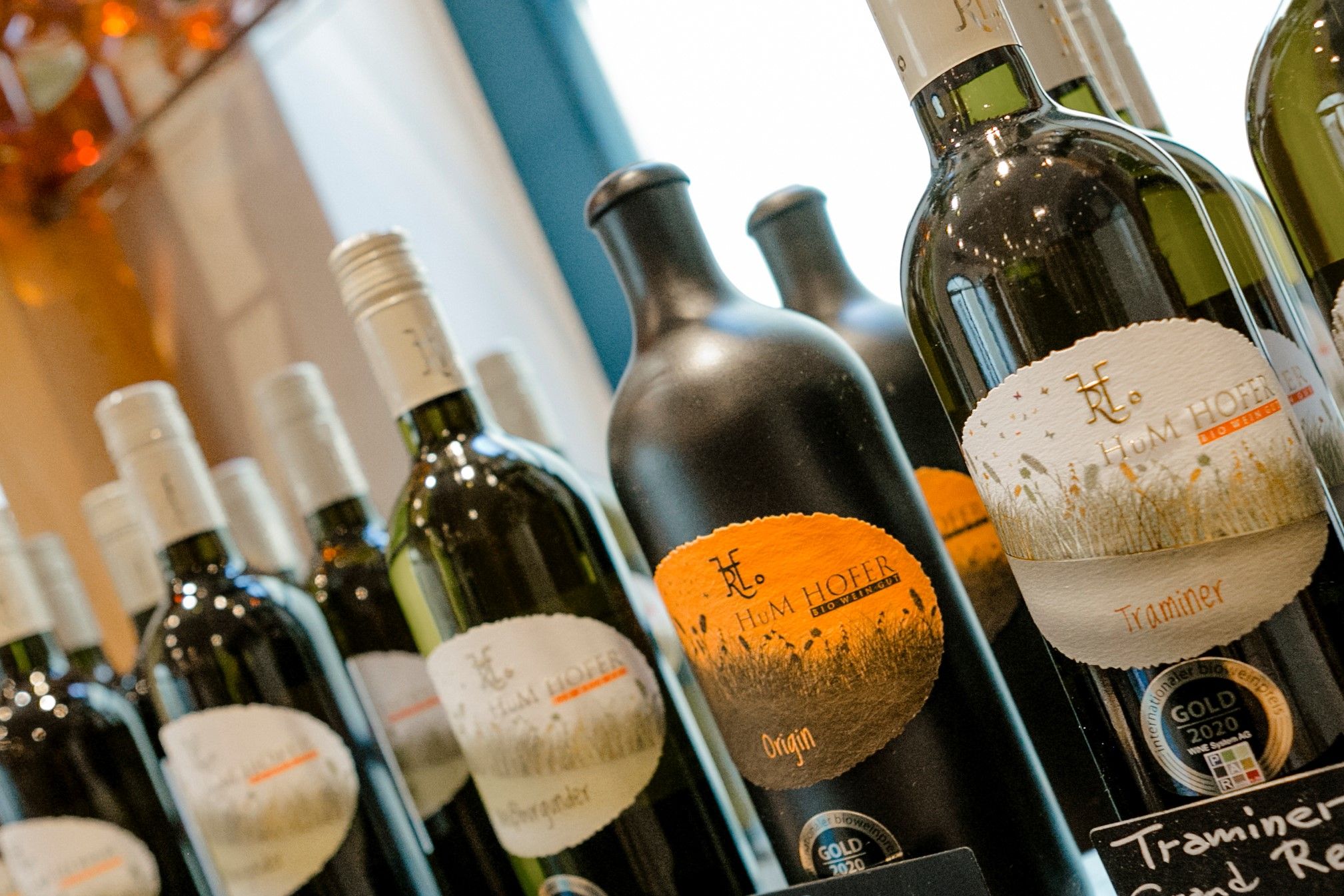 Nahaufnahme von Weinflaschen mit Etiketten der Marke Hum Hofer.