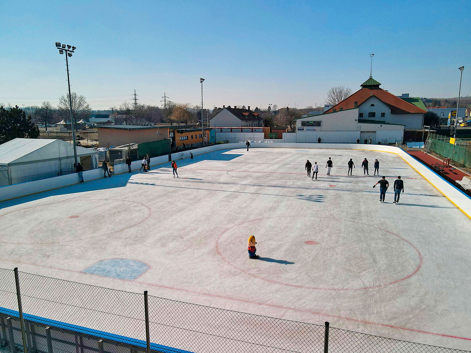 Eislaufbahn mit Menschen in Hollabrunn bei sonnigem Wetter.