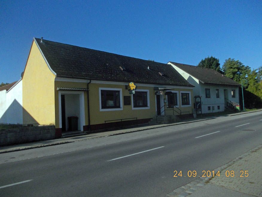 Außenansicht eines gelben Gasthofs an einer Straße mit Datum 24.09.2014.