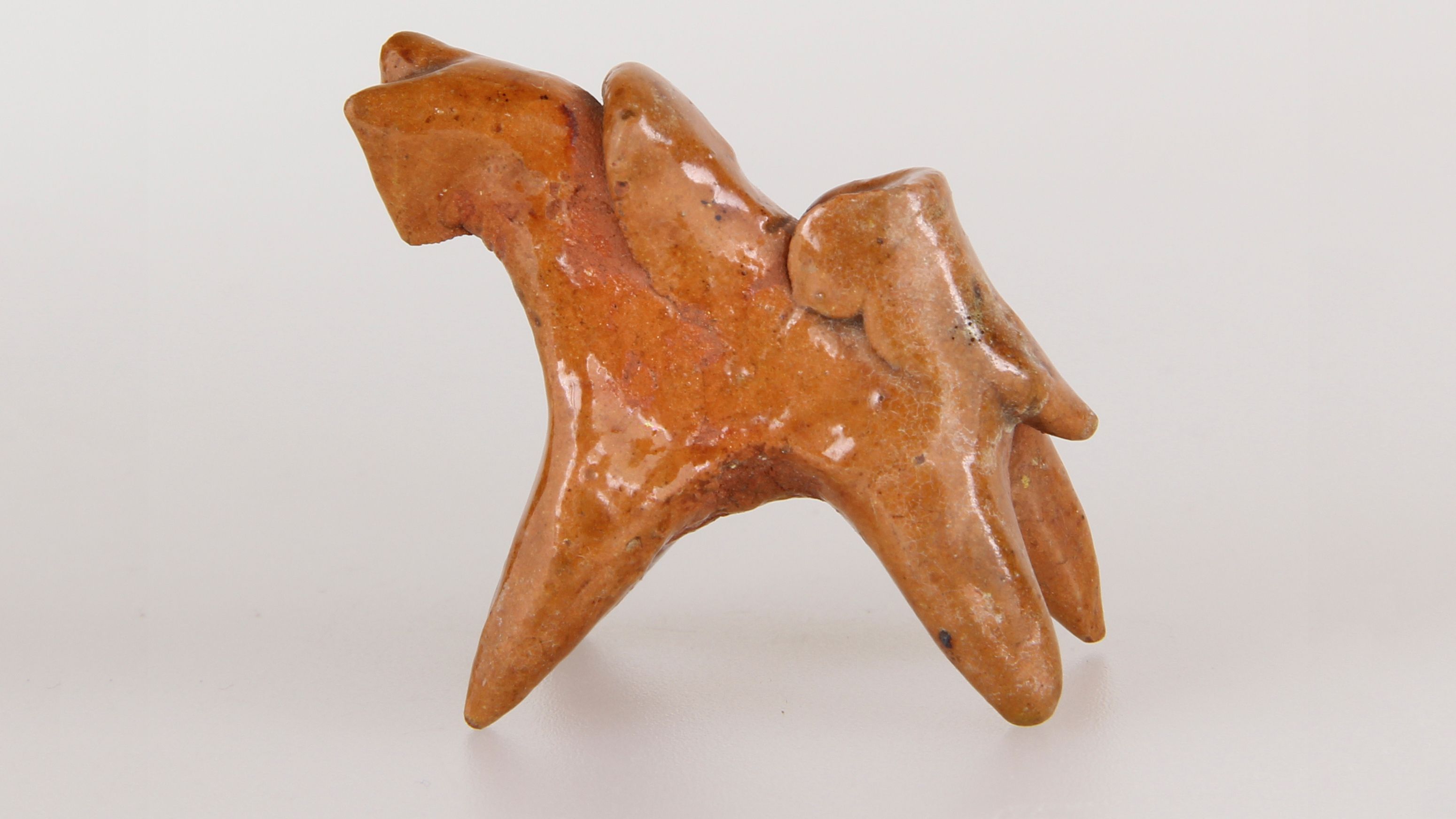 Keramikfigur eines stilisierten Pferdes mit Reiter.