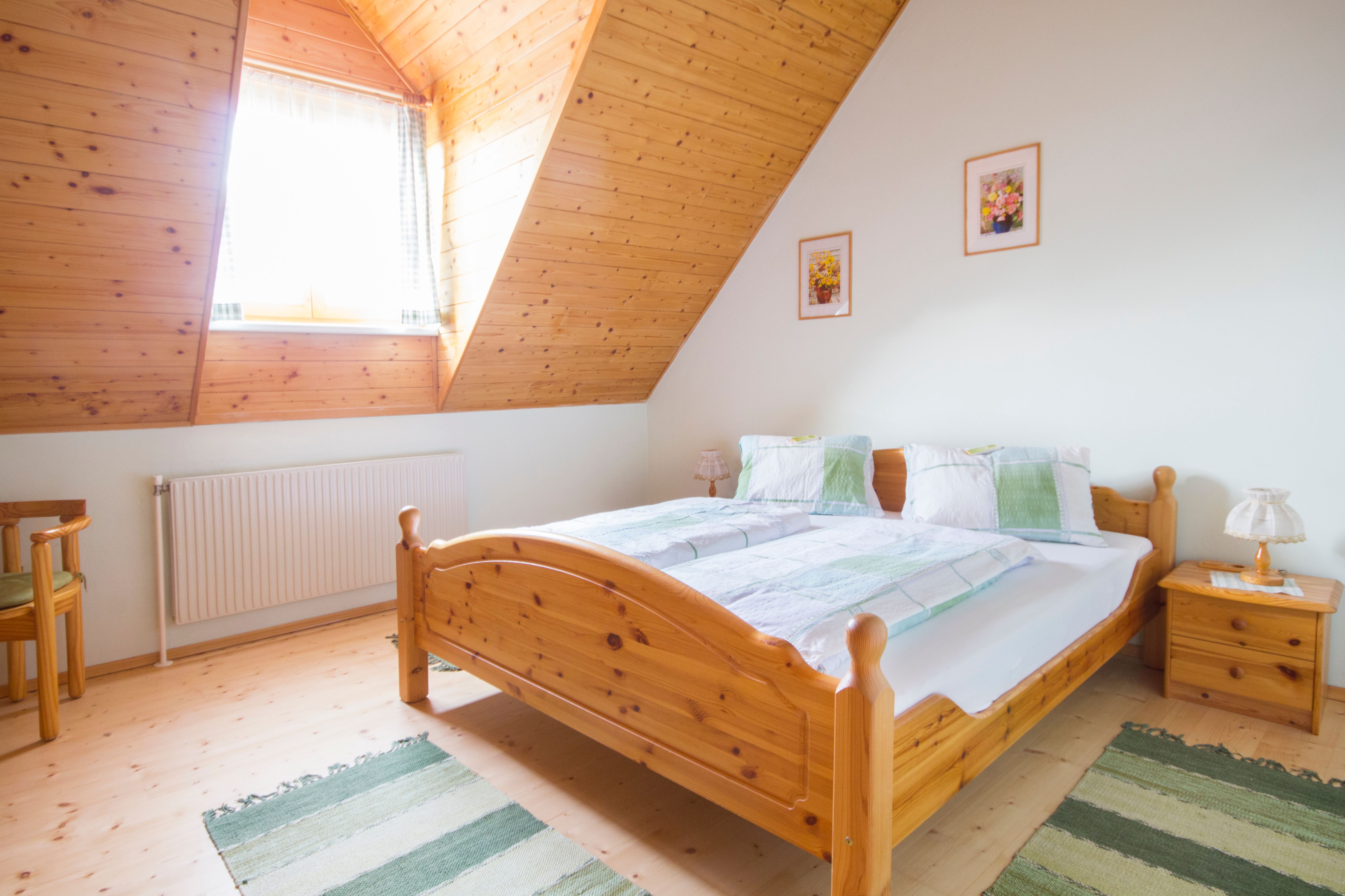 Gemütliches Schlafzimmer mit Holzmöbeln und Dachschräge.