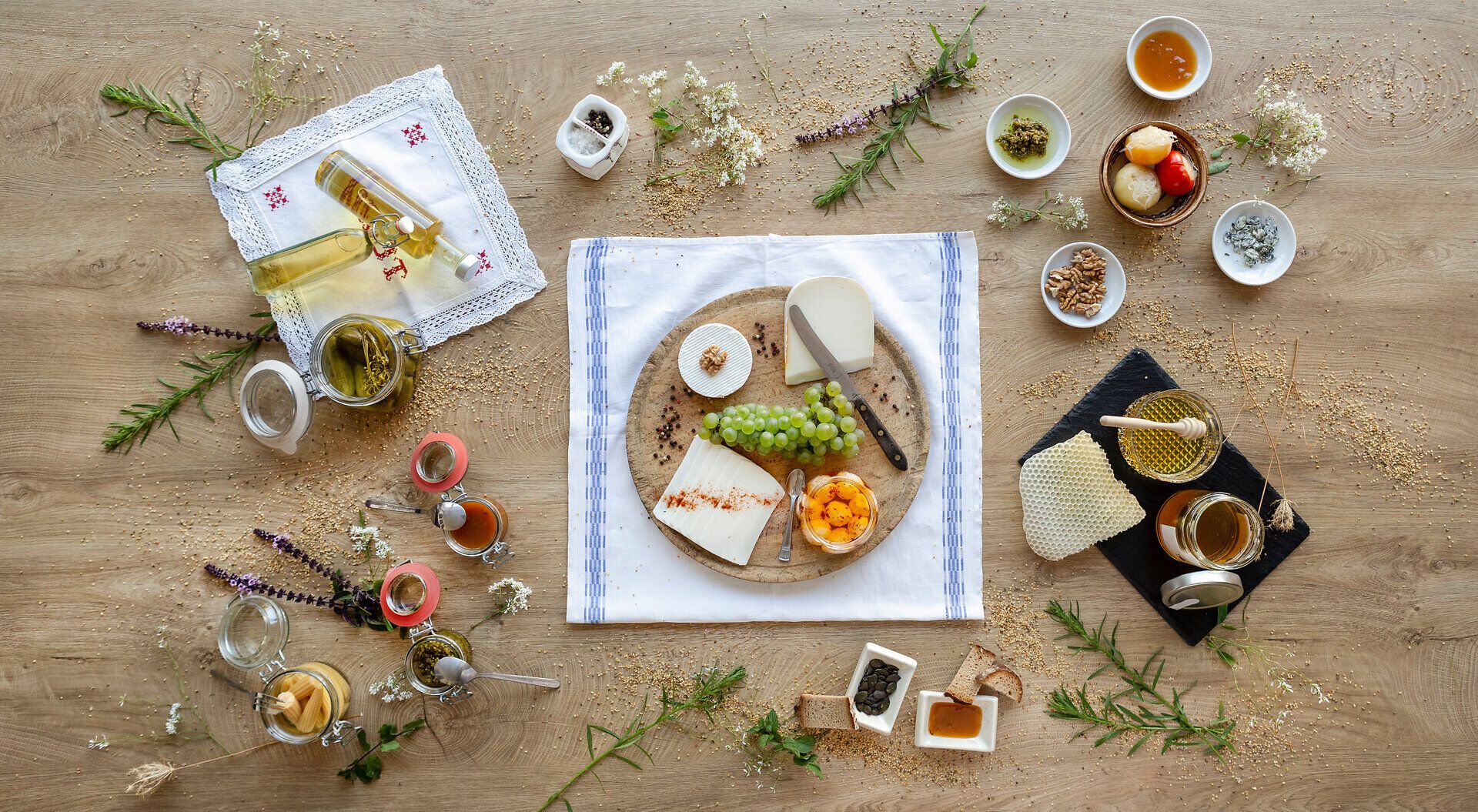 Ein liebevoll gedeckter Tisch lädt dazu ein, die Köstlichkeiten der Region zu genießen. Frischer Käse, aromatische Chutneys und süßer Honig harmonieren perfekt mit den knackigen Trauben und dem duftenden Öl. Diese kulinarische Vielfalt verspricht ein unvergessliches Geschmackserlebnis.