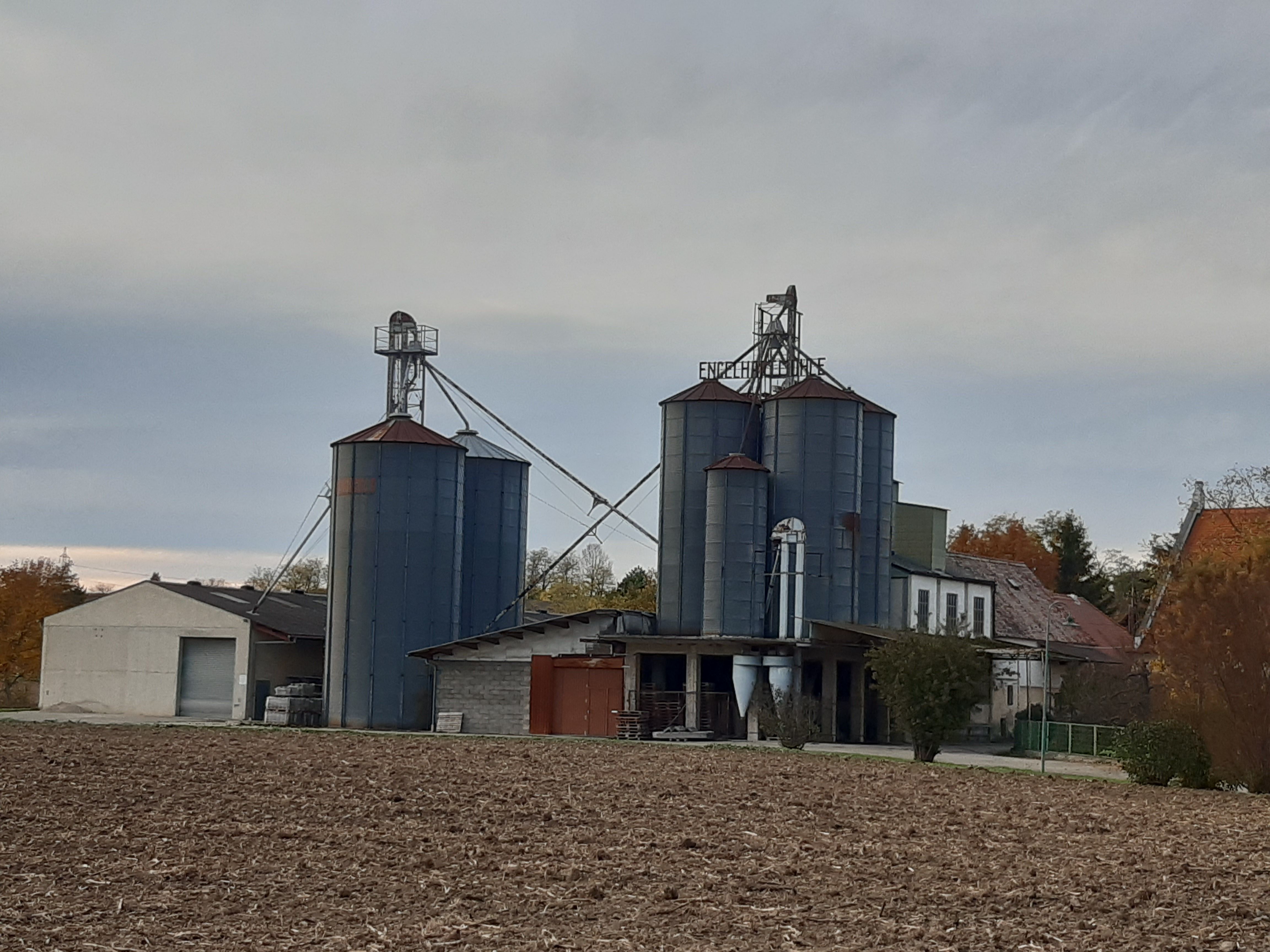 Industrieanlage mit Silos und Gebäuden auf einem Feld.