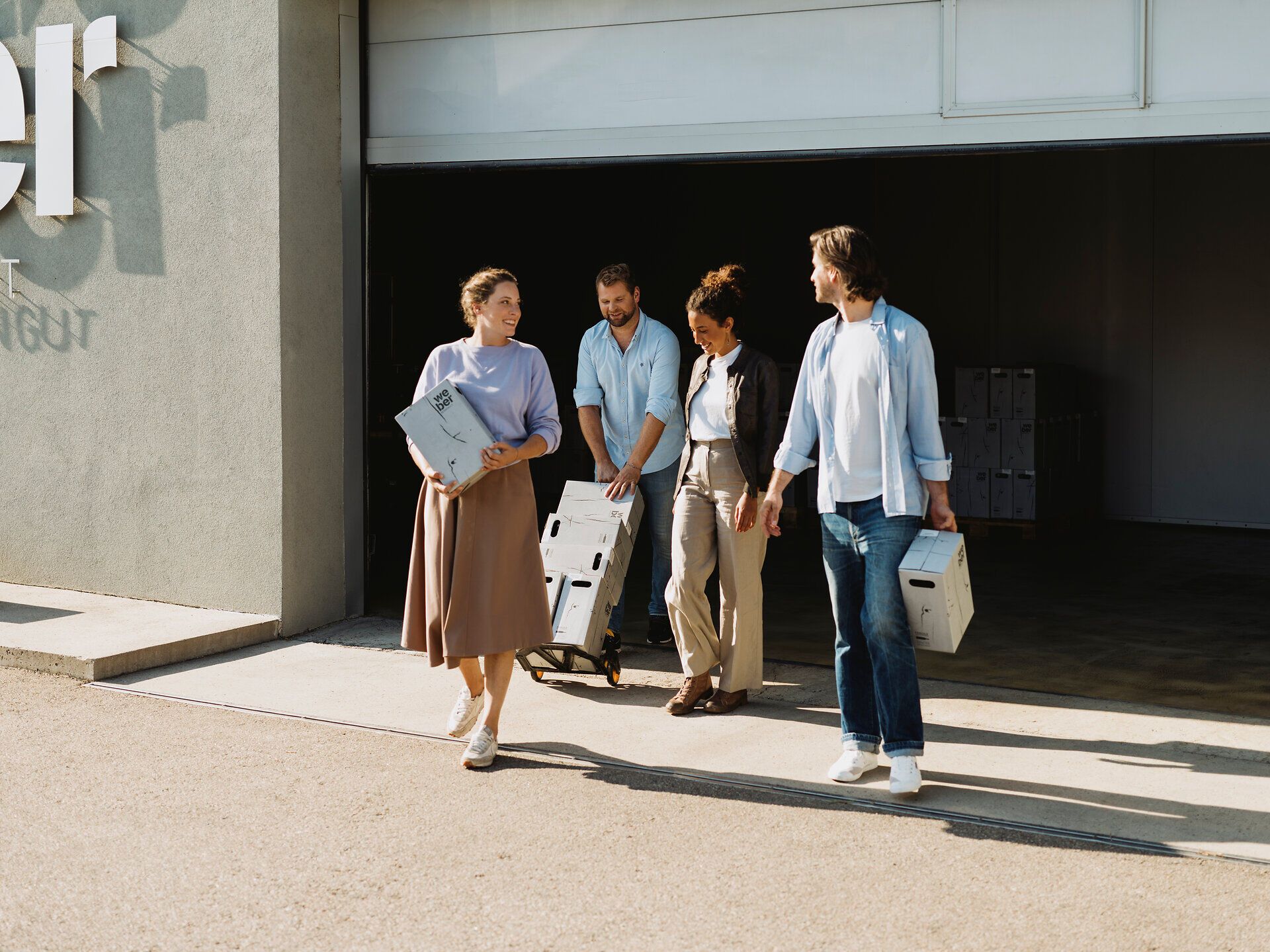 In der warmen Herbstsonne tragen fröhliche Menschen kistenweise frische Trauben vom Weinberg. Die Luft ist erfüllt von dem süßen Duft der reifen Früchte, während die sanften Hügel des Weinviertels im Hintergrund eine malerische Kulisse bieten. Ein perfekter Tag für Weinliebhaber, um die Erntezeit zu feiern.