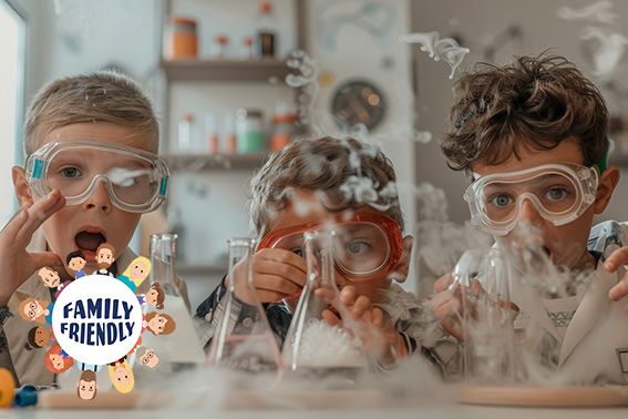 Drei Kinder mit Schutzbrillen führen in einem Klassenzimmer ein lustiges wissenschaftliches Experime