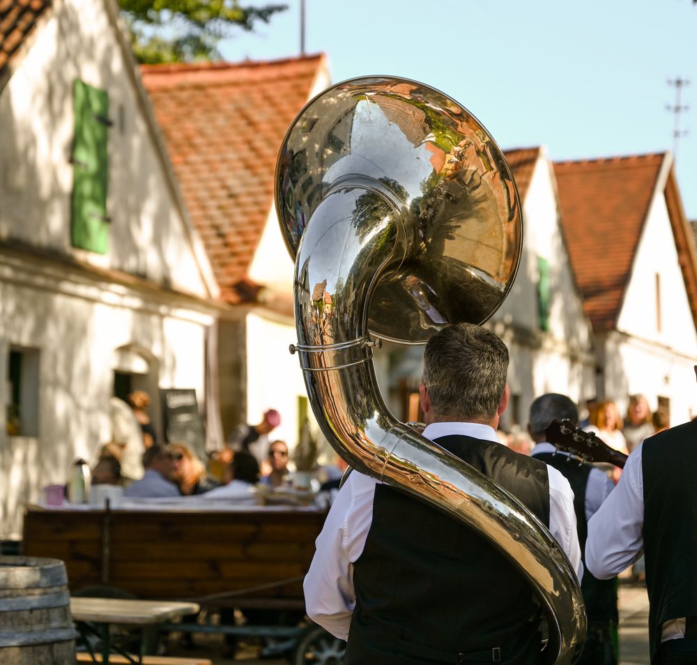 Ein festlicher Klang erfüllt die Luft, während die Musikanten mit ihren Instrumenten die Besucher in eine fröhliche Stimmung versetzen. Umgeben von charmanten Weinhäusern und der malerischen Landschaft, genießen die Gäste die köstlichen Weine und die kulturellen Darbietungen des Kellergassenfests.