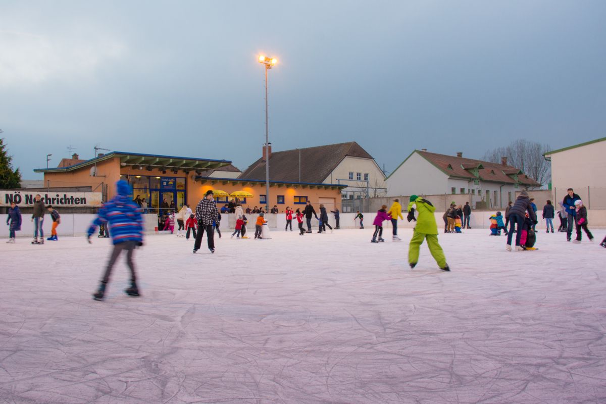 Menschen beim Eislaufen auf einer Kunsteisbahn in Hollabrunn.