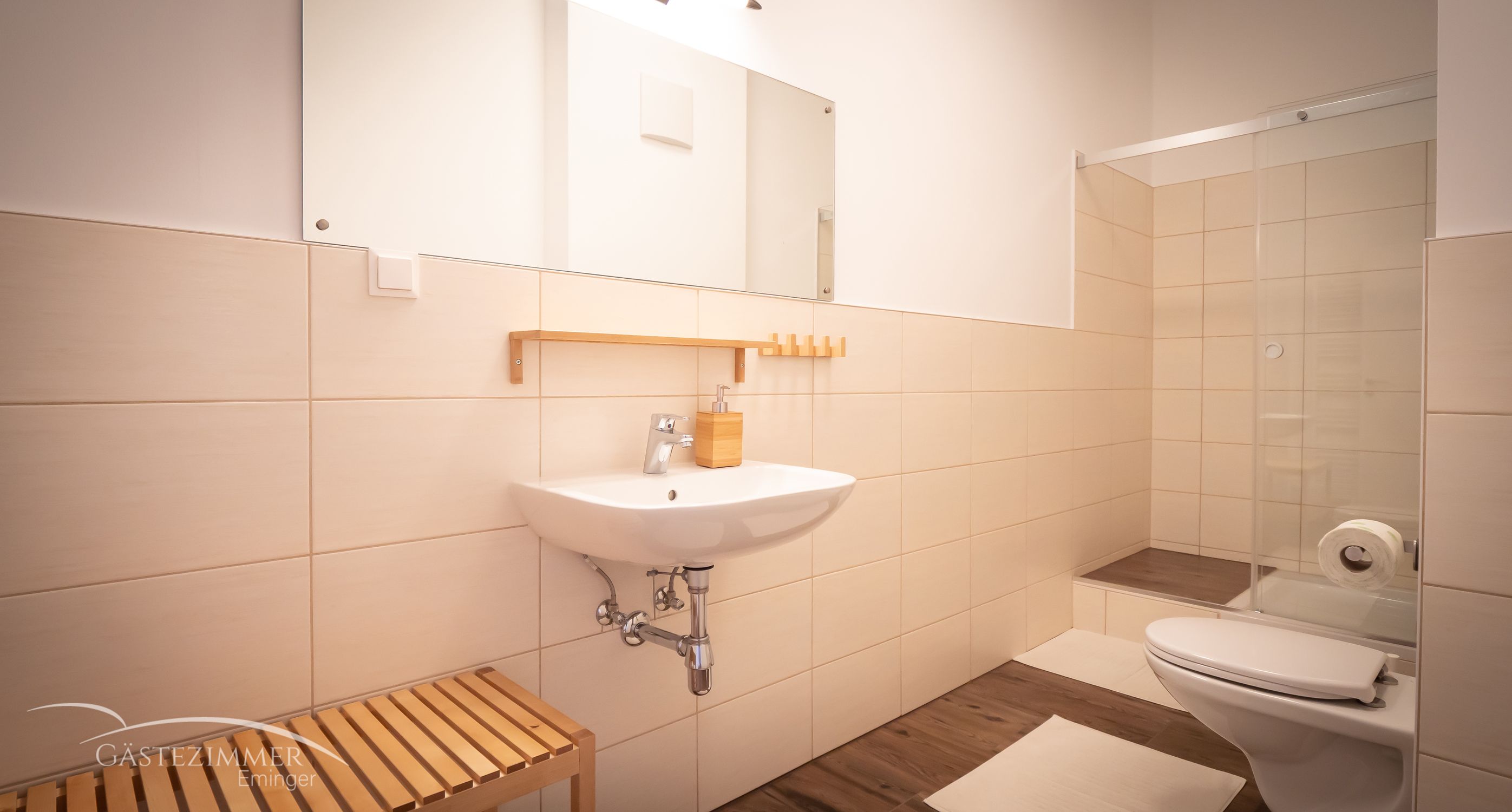 Modernes Badezimmer mit Waschbecken, Spiegel, Dusche und Toilette.