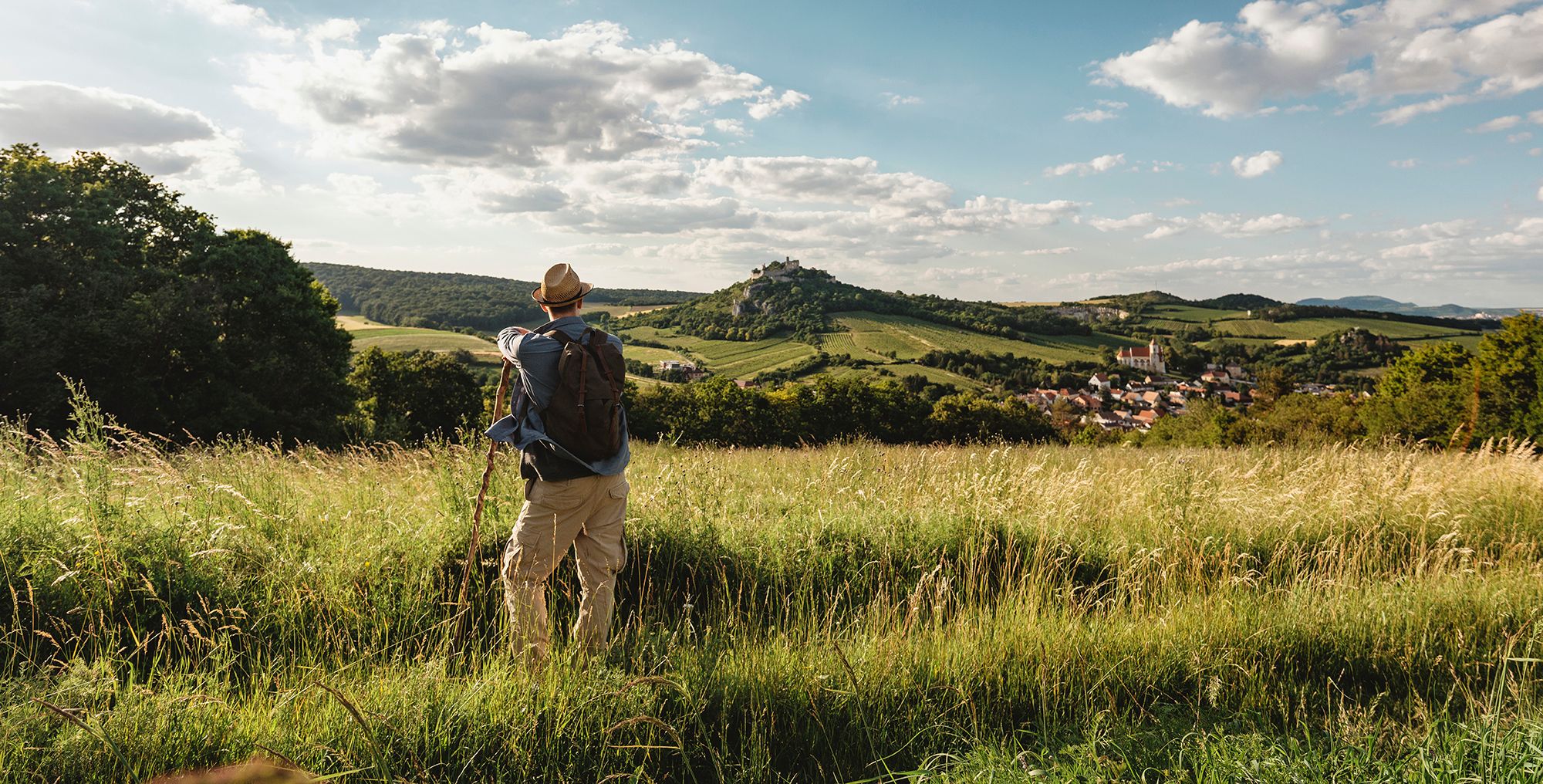 Ein Wanderer blickt auf die Burgruine Falkenstein