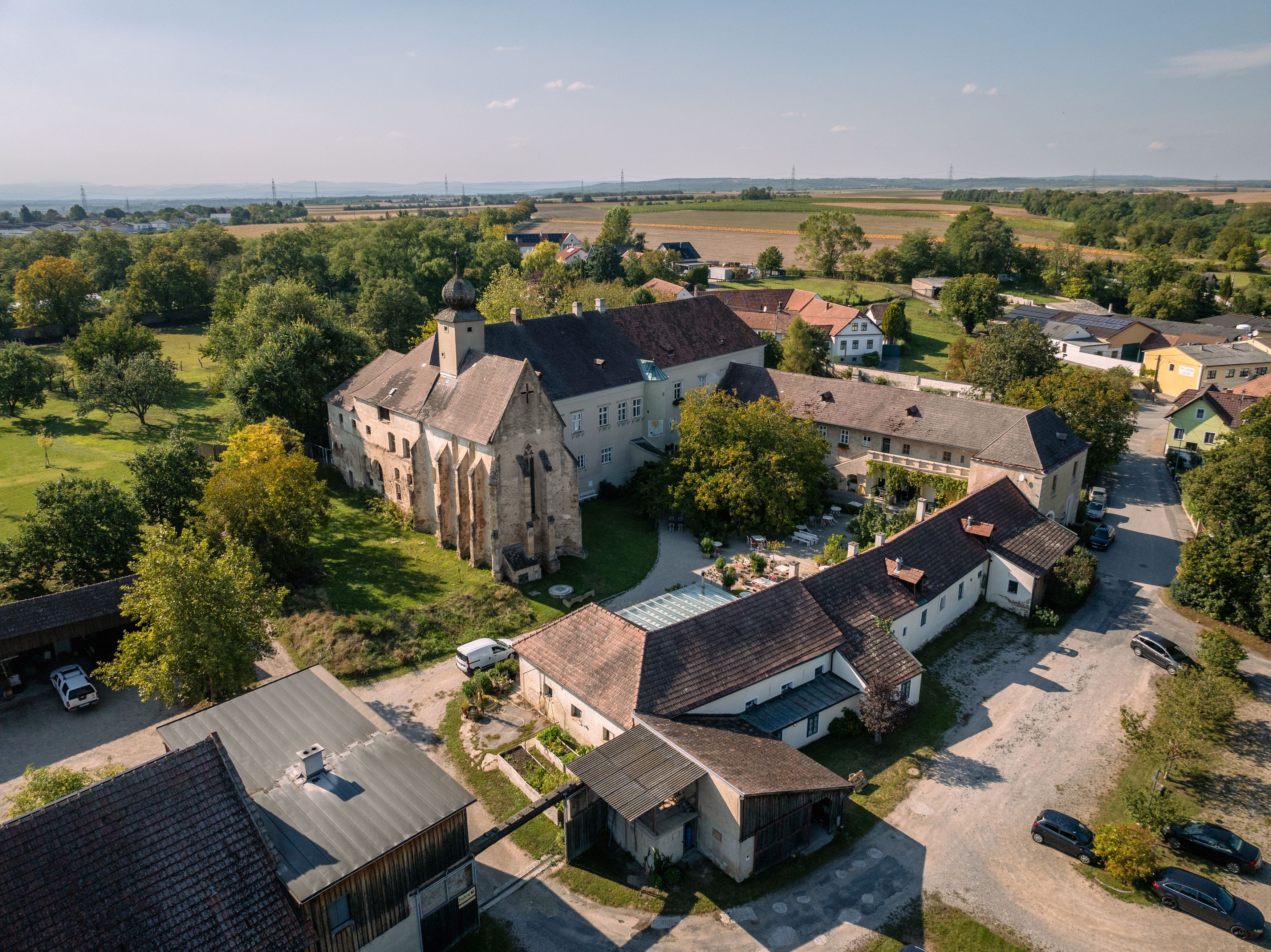 Luftaufnahme von Gut Oberstockstall mit historischen Gebäuden und grüner Umgebung.