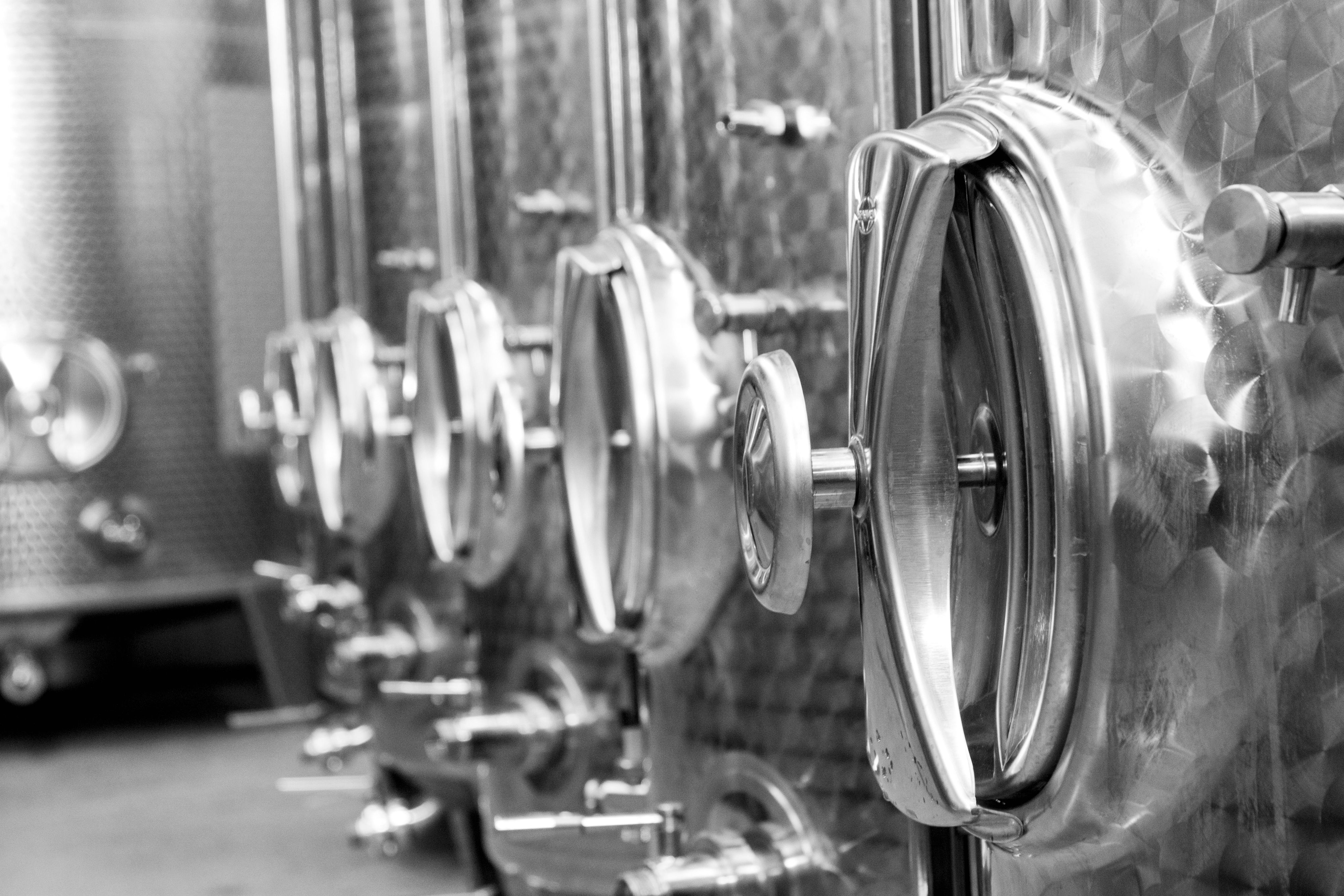 Close-up of stainless steel wine tanks in a row.