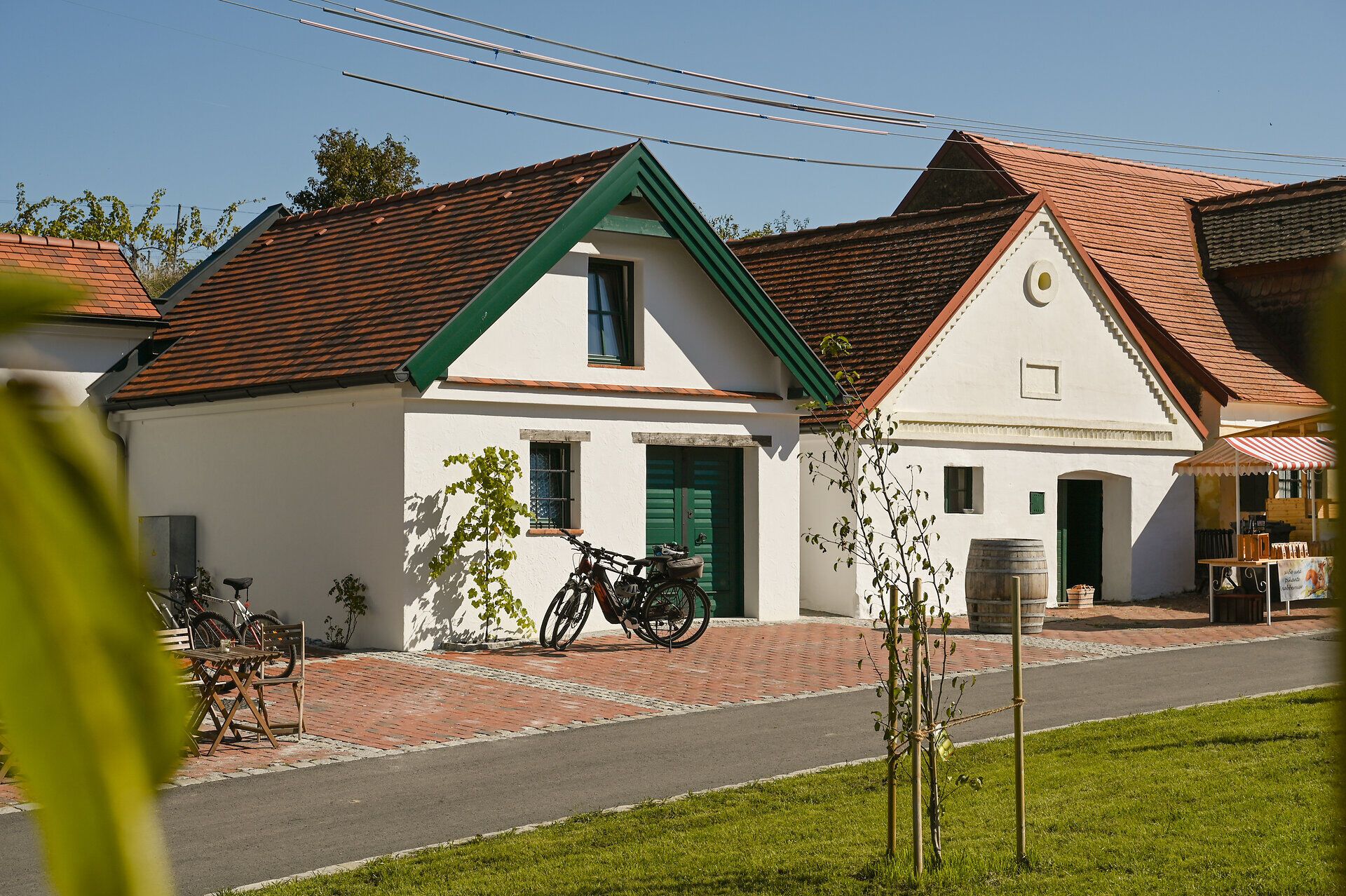 In der malerischen Kellergasse laden einladende Weinhäuser und kunstvolle Stände zum Verweilen ein. Die sanfte Brise trägt den Duft von frischem Wein und köstlichen Speisen, während die Sonne die charmanten Gebäude in warmes Licht taucht. Ein Fest für die Sinne, das die Schönheit des Weinherbstes zelebriert.