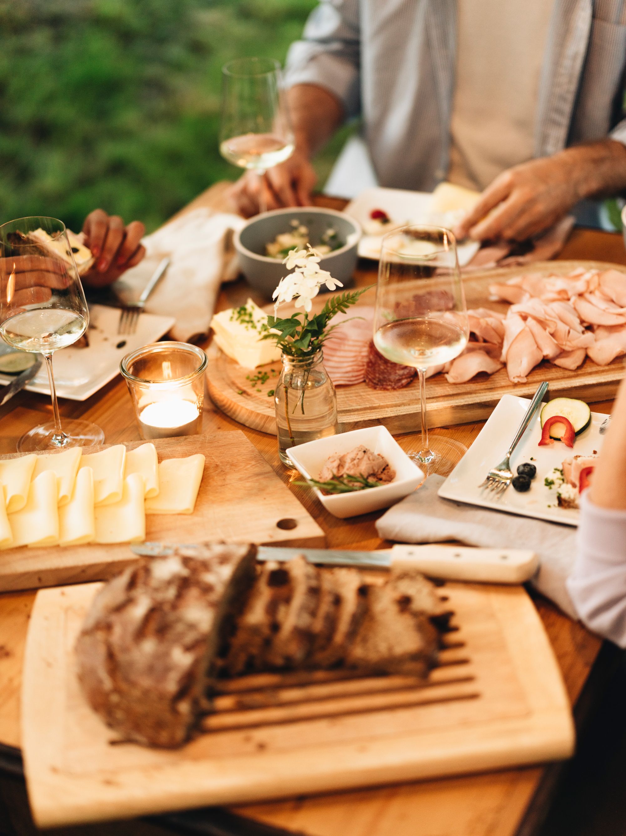 Ein gedeckter Tisch mit Brot, Käse, Aufschnitt und Weingläsern.