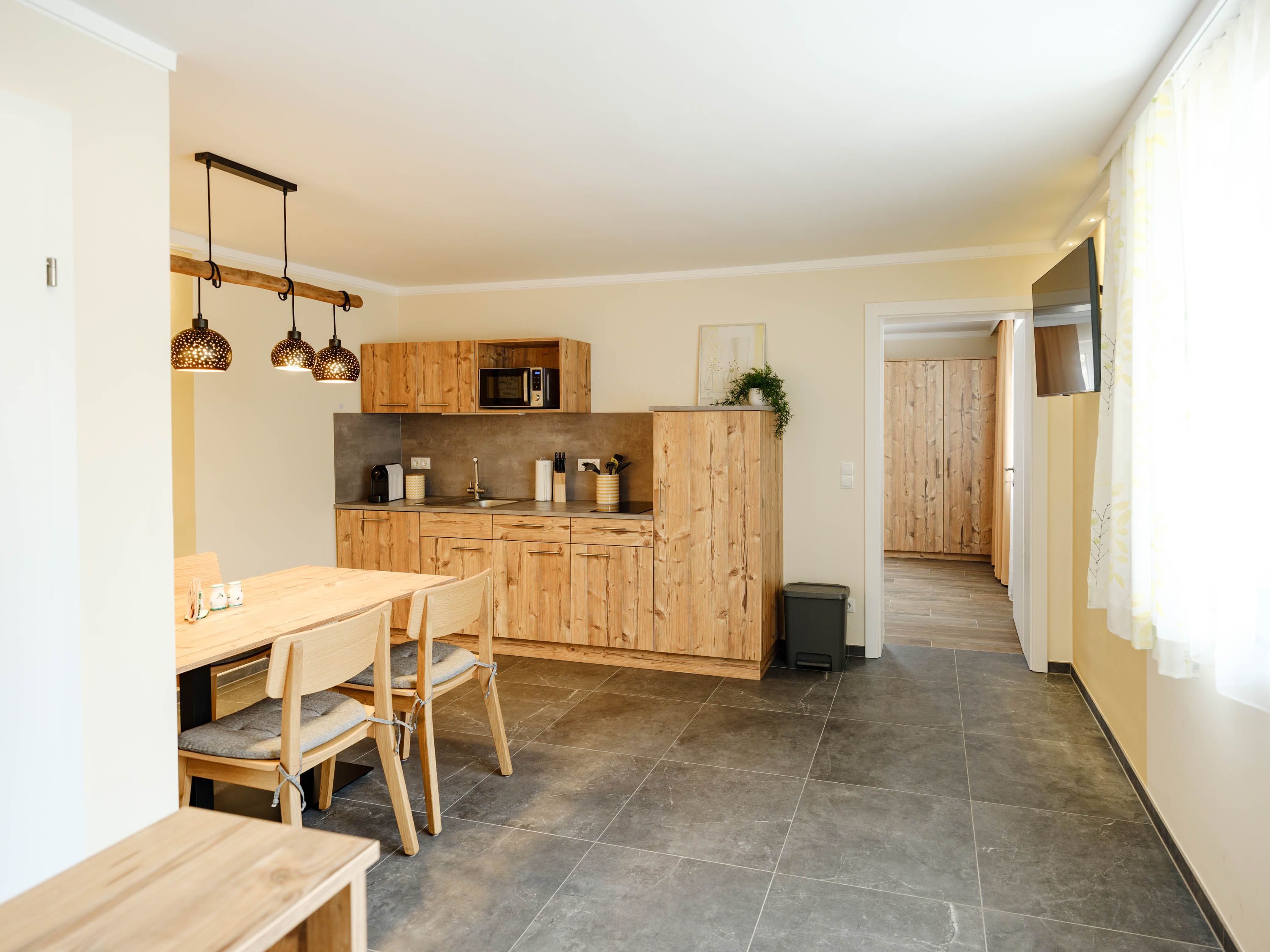 Moderne Küche mit Holzmöbeln und Hängelampen.