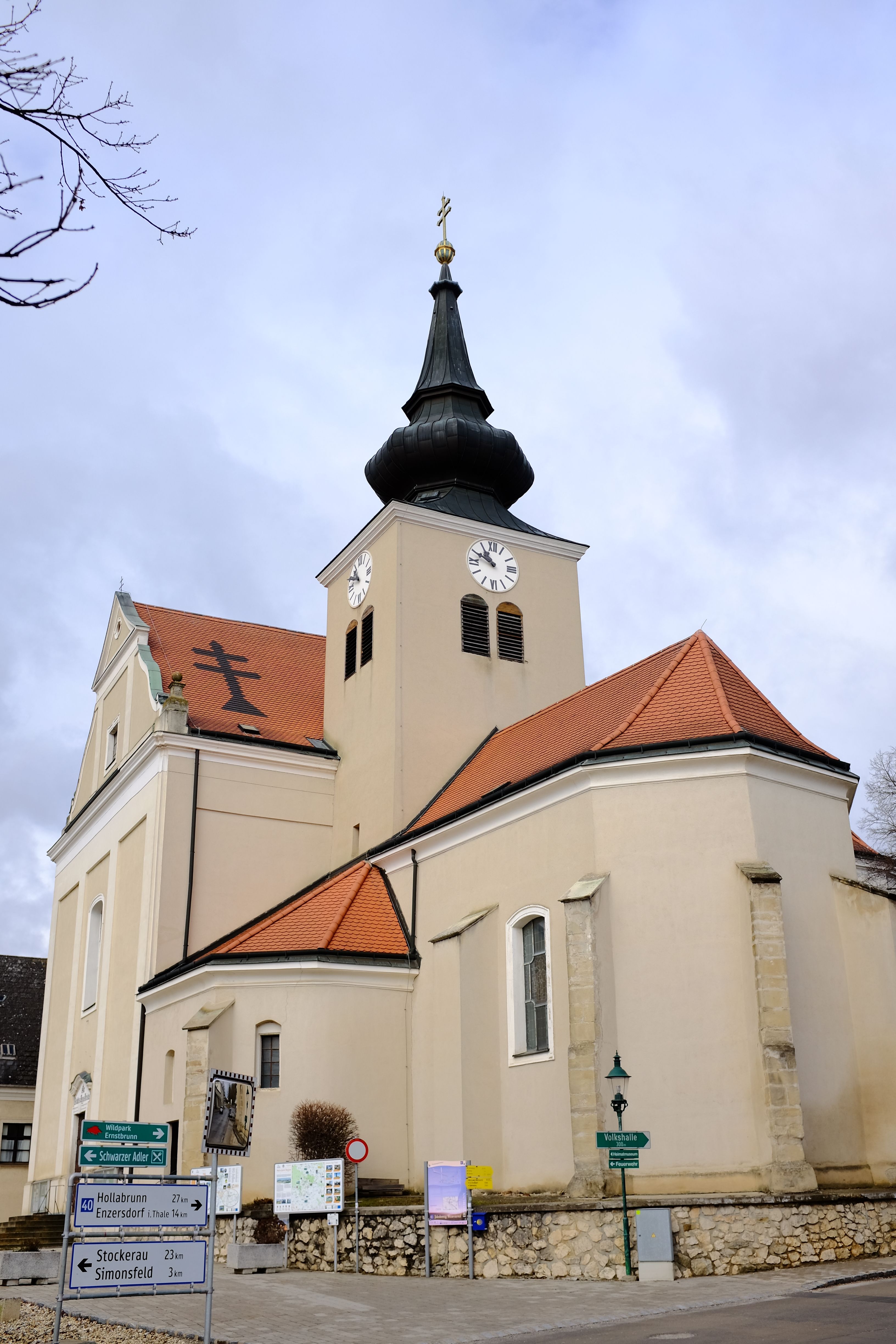 Parish church of St. Martin in Ernstbrunn with clock tower and red tiled roofs.