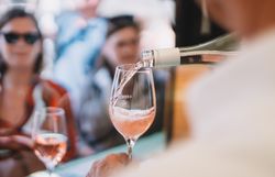 Einer Personengruppe wird sprudeliger Frizzante Rosé eingeschenkt. 