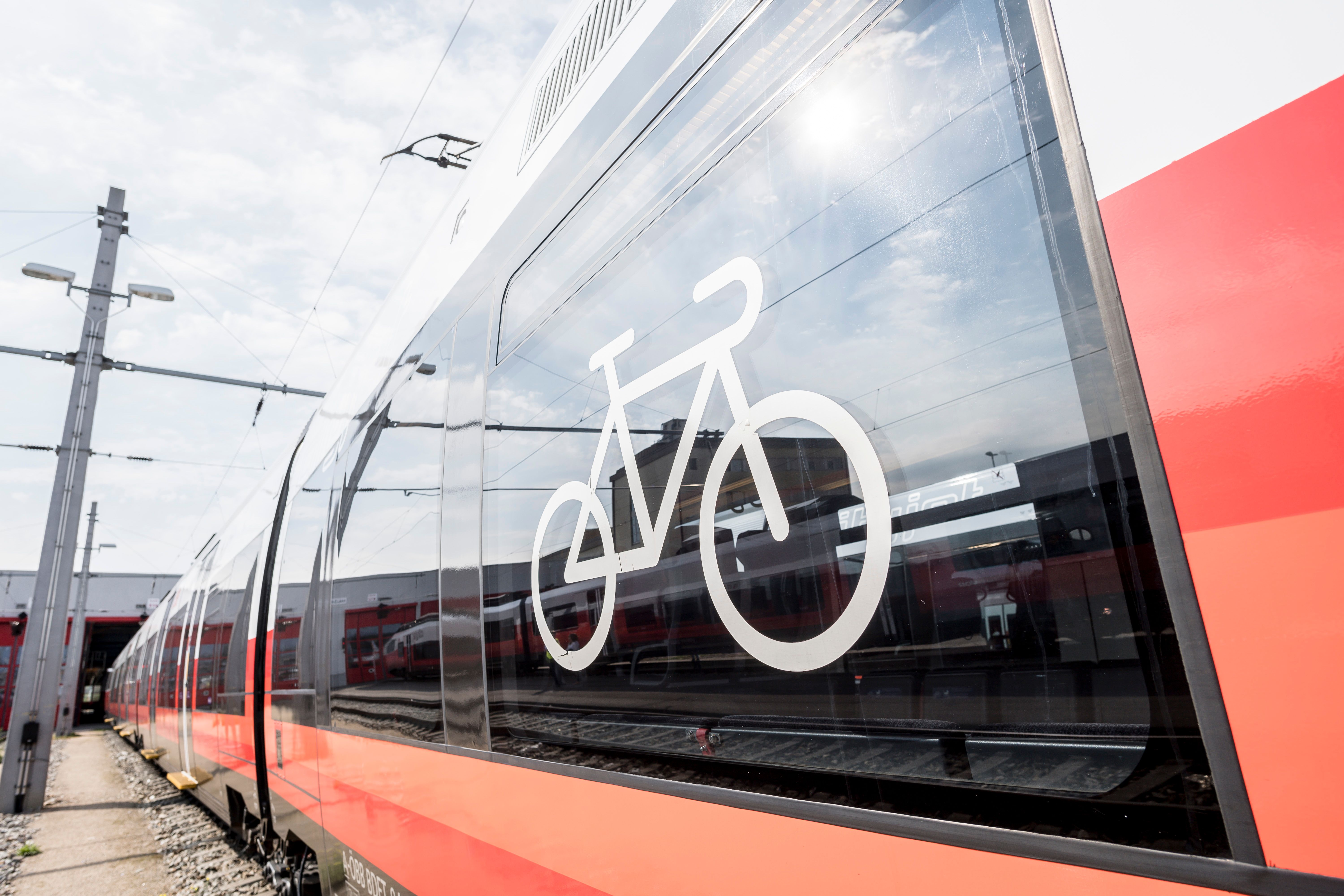 Close-up of a red train with a bicycle symbol on the window.