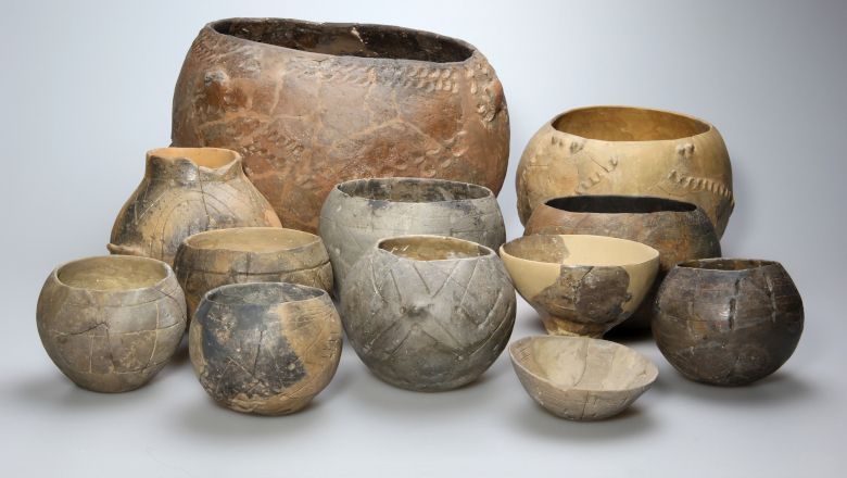 Various antique ceramic vessels in different sizes and colors.