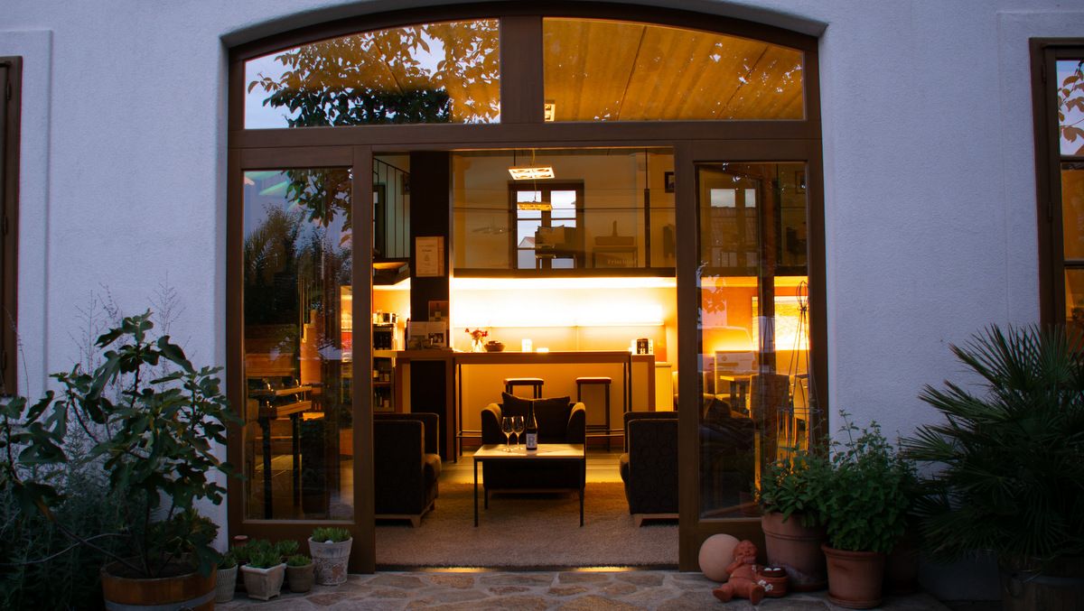 A cozy tasting room with open doors, plants and warm light.