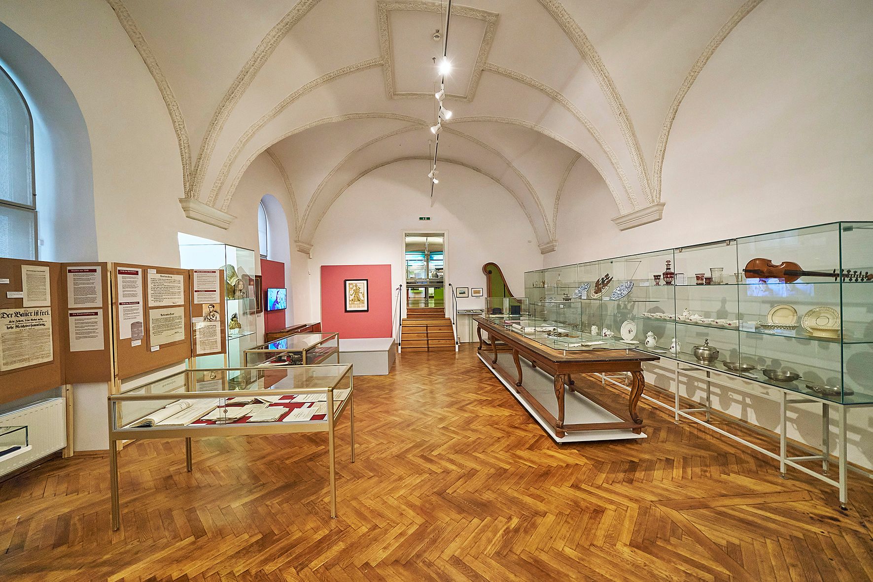 Innenansicht eines Museumsraums mit Vitrinen und Ausstellungsstücken.